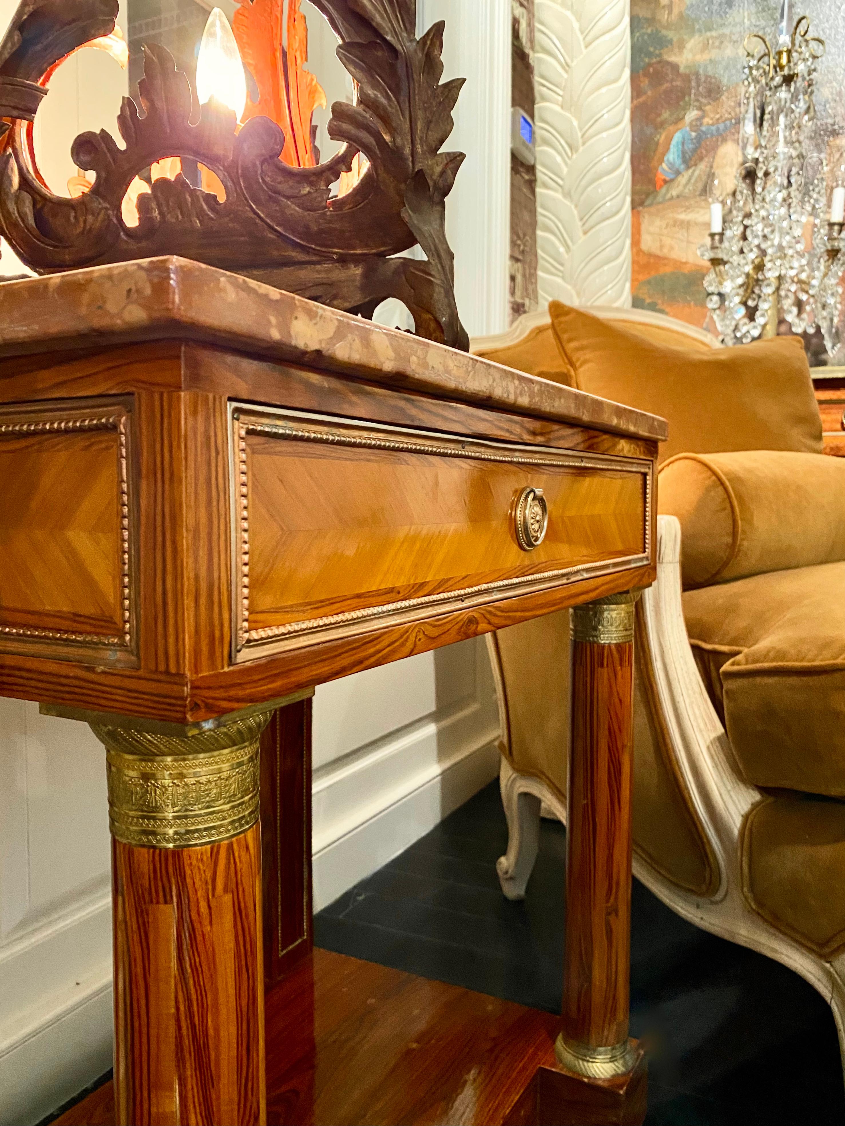 Empire style marble-top nightstand or console. One drawer and lower ledge, gilt bronze details and neoclassical columns.