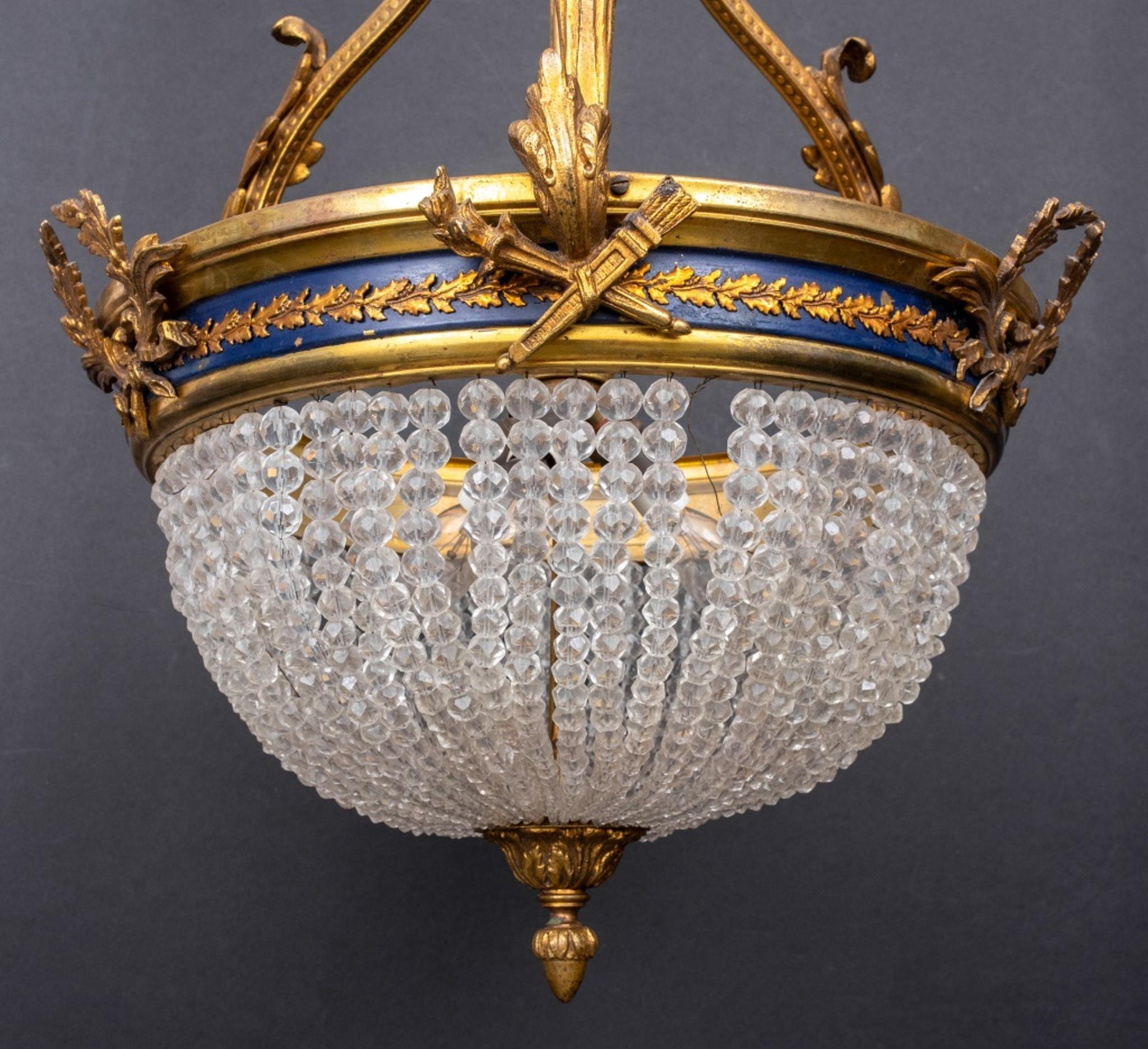 Empire style Montgolfier basket chandelier in gilt bronze monture with blue band and laurel motif, above a faceted crystal glass bead basket. In very good vintage condition. 

Dealer: S138XX
