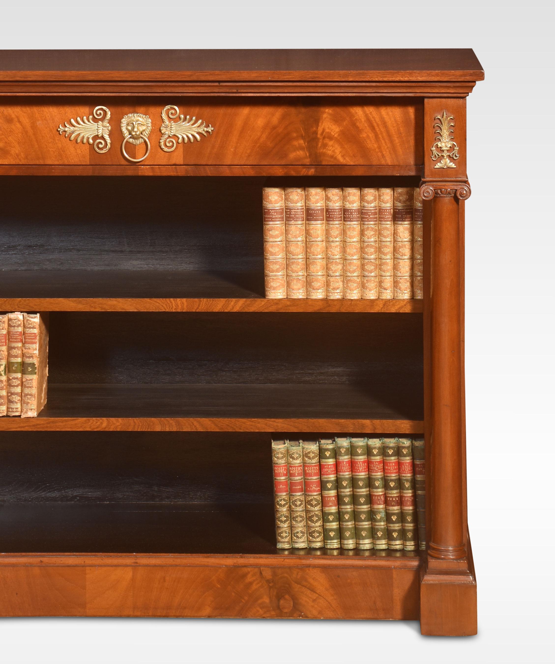 Mahogany open bookcase the rectangular well-figured top above large freeze drawer with central brass motif. To the adjustable shelved interior flanked by circular columns with brass capitals. All raised up on a plinth base.
Dimensions
Height 36.5