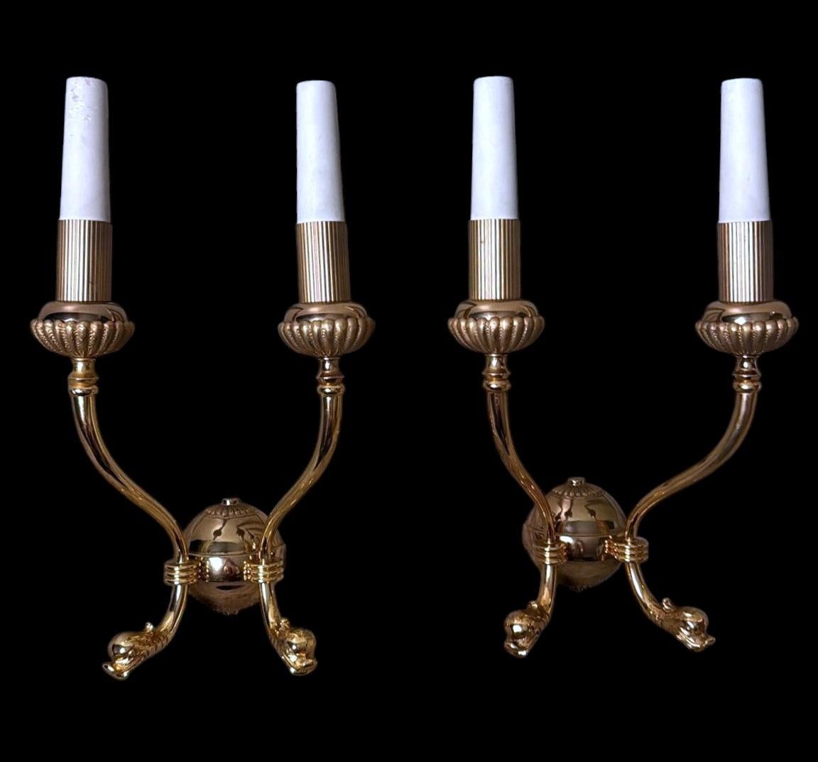 Élégante paire d'appliques italiennes à deux lumières en laiton doré poli, inspirées du goût Empire et néoclassique très apprécié en Italie et en France entre la fin du XIXe et le début du XXe siècle. Réalisé entre 1950 et 1955 dans un atelier