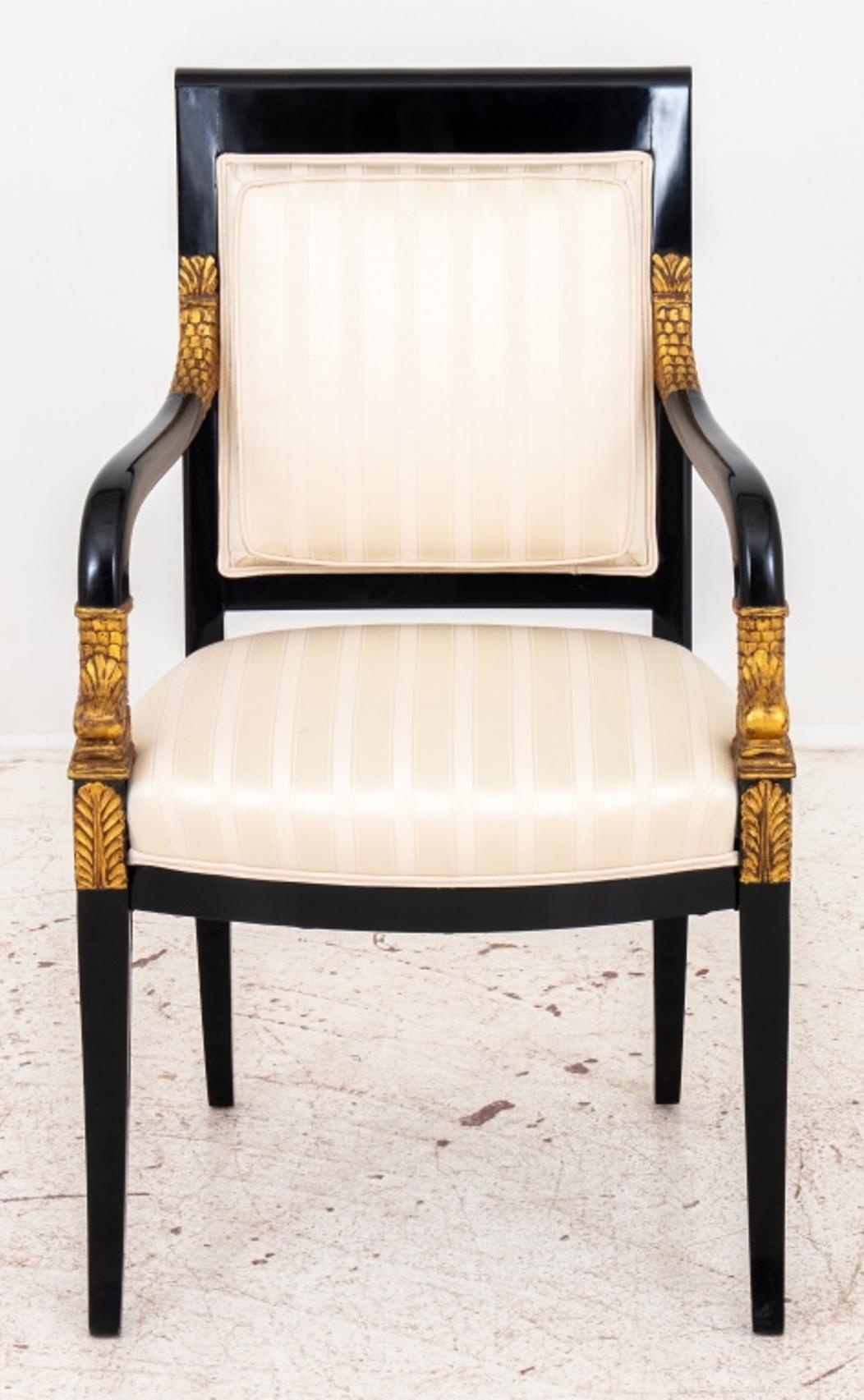 French Empire style ebonized wood armchair raised on saber legs, enhanced with gilt carved dolphin heads to arms, upholstered in cream fabric.

Dimensions: 37