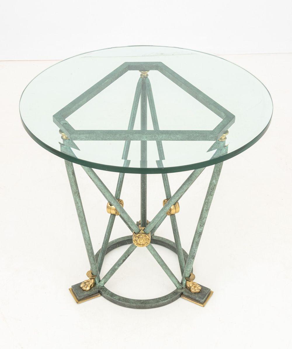 Empire Style Verdigris Patinated and Gilt Metal Occasional Table, with beveled glass top above tripod base with lion's paw feet atop a circular support. 23.5
