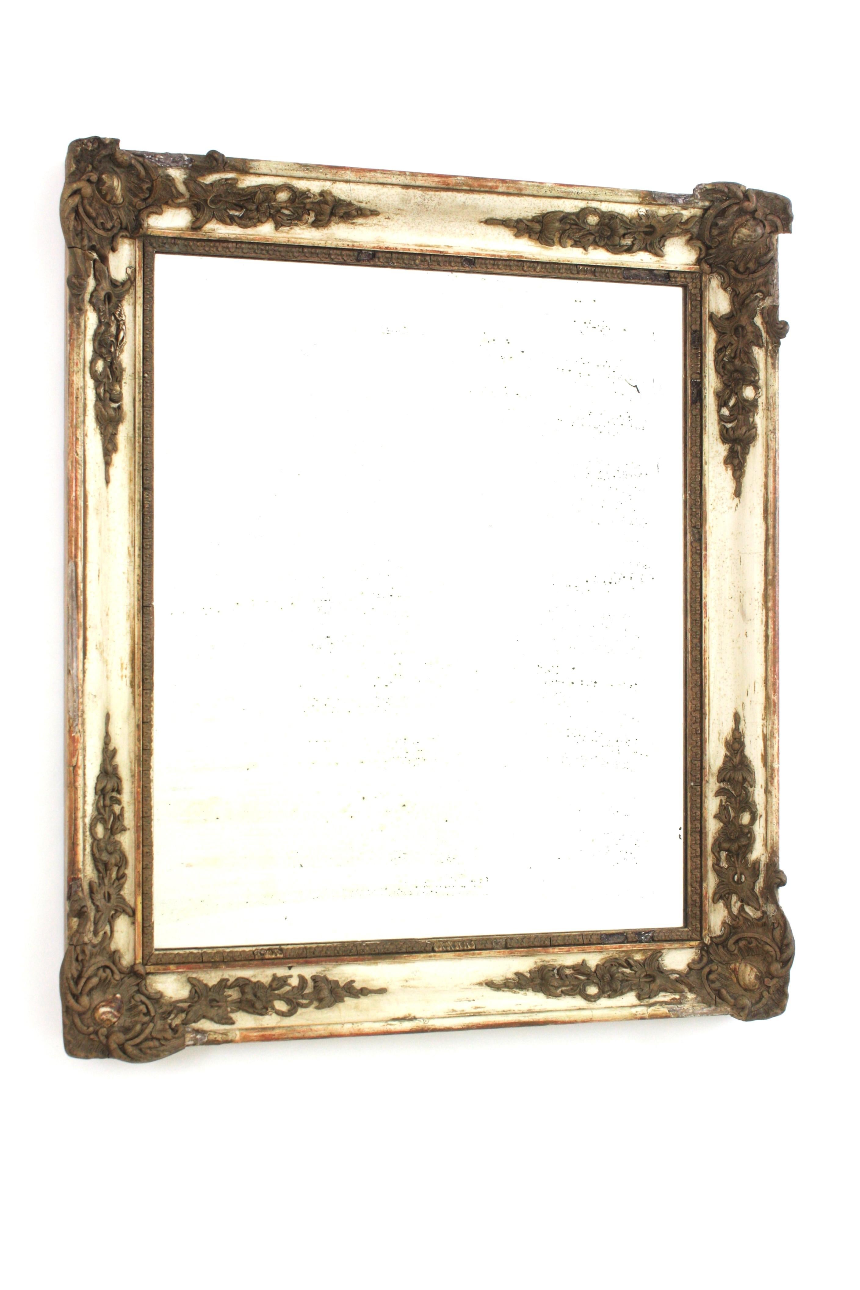Miroir de style Empire, France, années 1930.
Magnifique miroir rectangulaire de style Empire en patine beige avec ornementation néoclassique de feuillages et de fleurs en relief avec détails dorés. 
Le cadre présente une superbe patine d'ancienneté