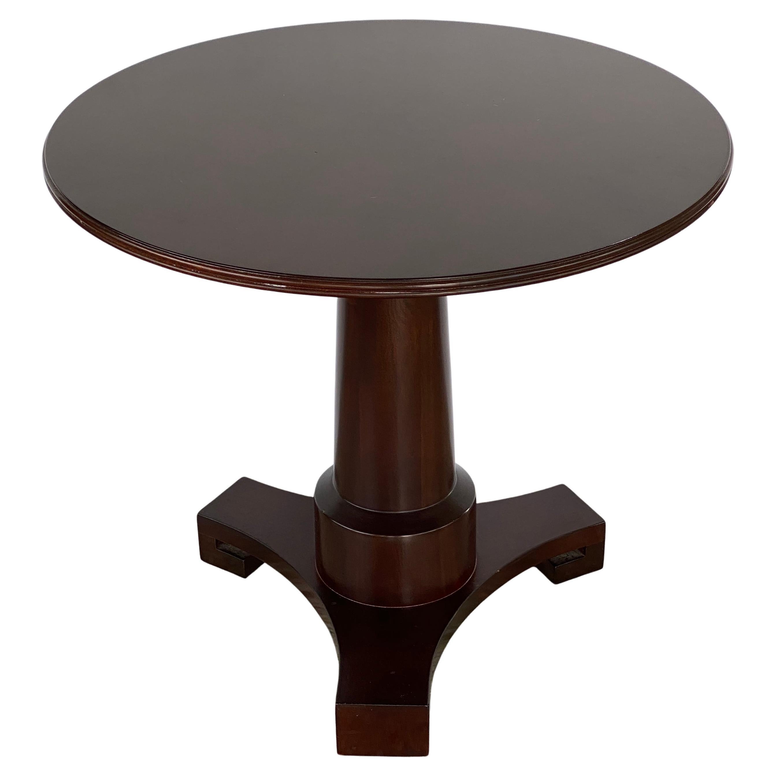 This stylish and chic French Empire revival side table was created in the 1980s-1990s, by the American firm of Baker Furniture. 

The piece is fabricated in mahogany and burl veneers in a deep mahogany coloration. 

Note: The top has a few