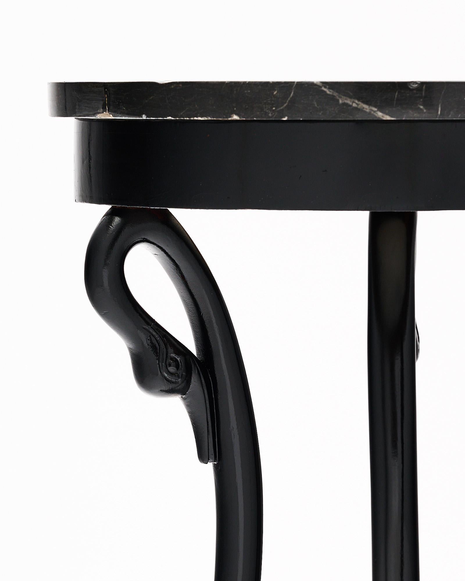 Gueridon, French, in the Empire style. This piece has three swan legs on a triangular base supporting the top covered with a veined black marble top (professionally repaired).