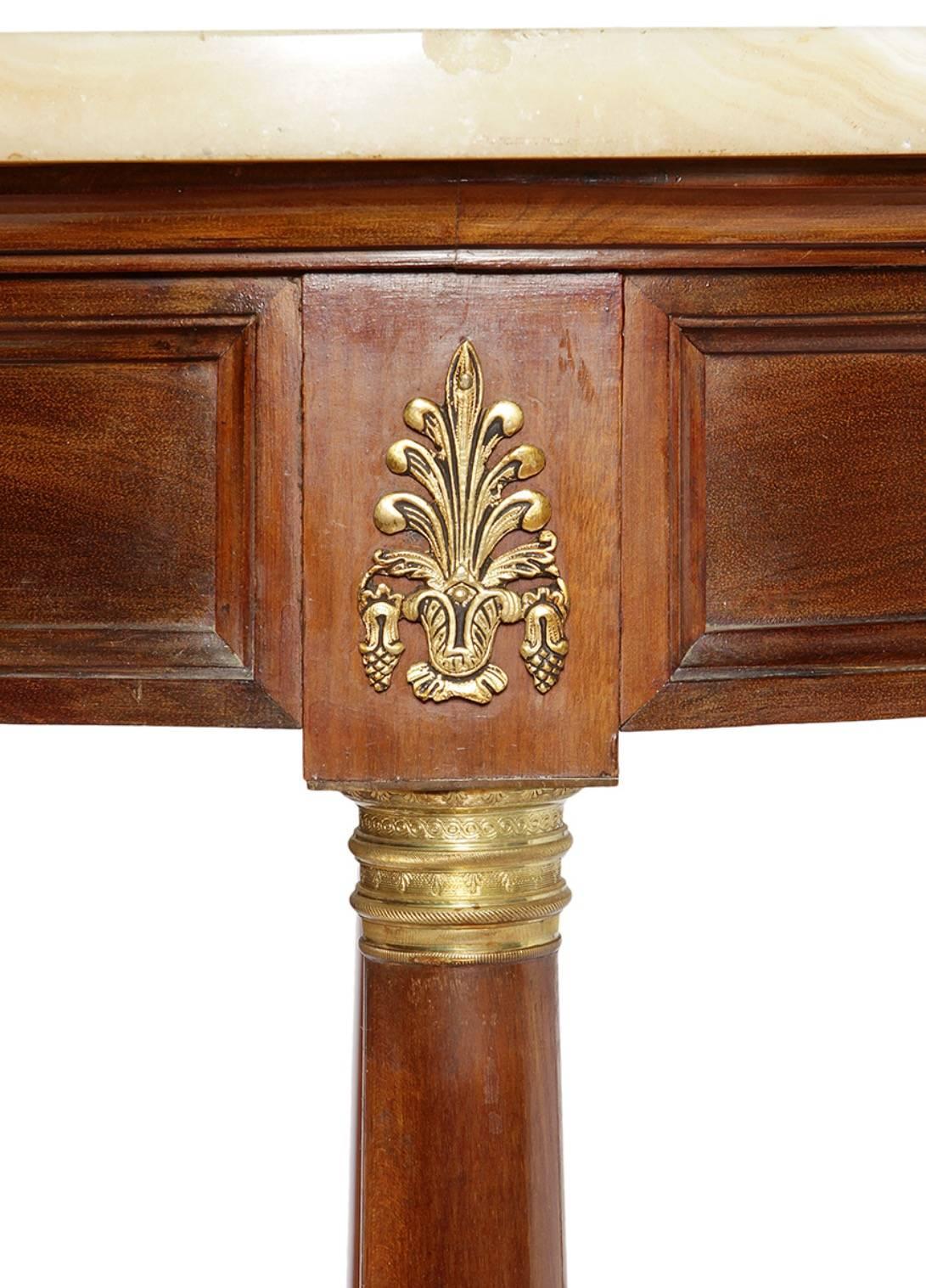 Auxiliary table Empire style, with structure in wood in its color, ornamental applications in bronze and onyx bronze. Of circular plan, it rises on four legs in the form of a column, united by a molded 