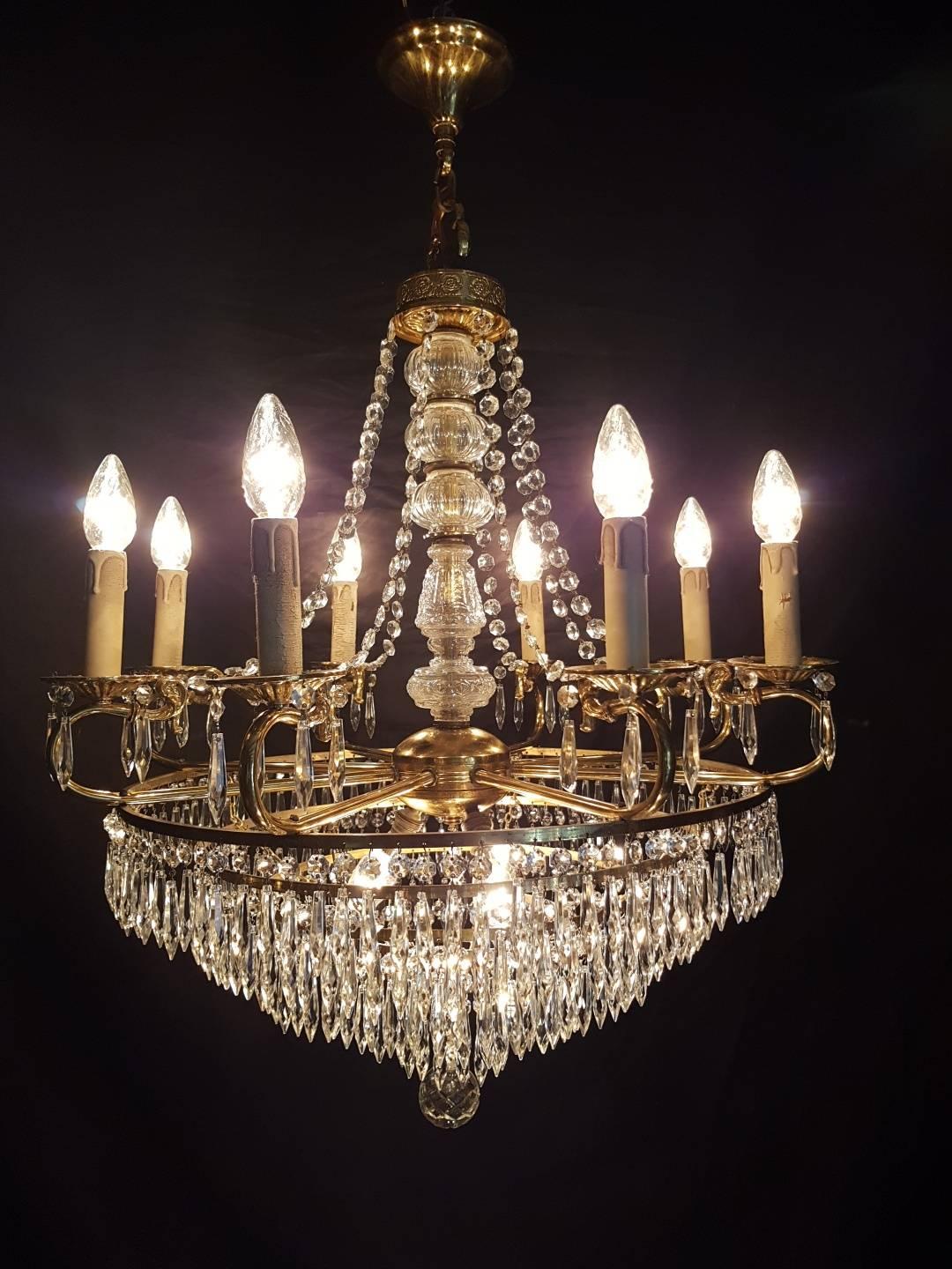 Waterfall chandelier in empire style with eleven lights. Eight candle lights and three lights inside the chandelier. 'The Waterfall' is a total of five metal rings with point-shaped crystals. In the centre a very nice crystal ball.

This is just