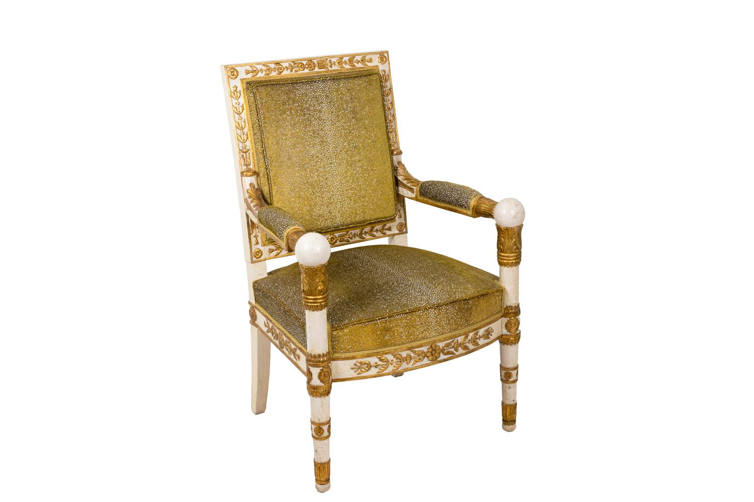 Empire style white carved wood with gold highlights pair of armchairs.
Standing on two front tapered legs and two back saber legs. Straight apron and uprights, rectangular backseat and seat.
Spherical handling part of the armrests, reminding the