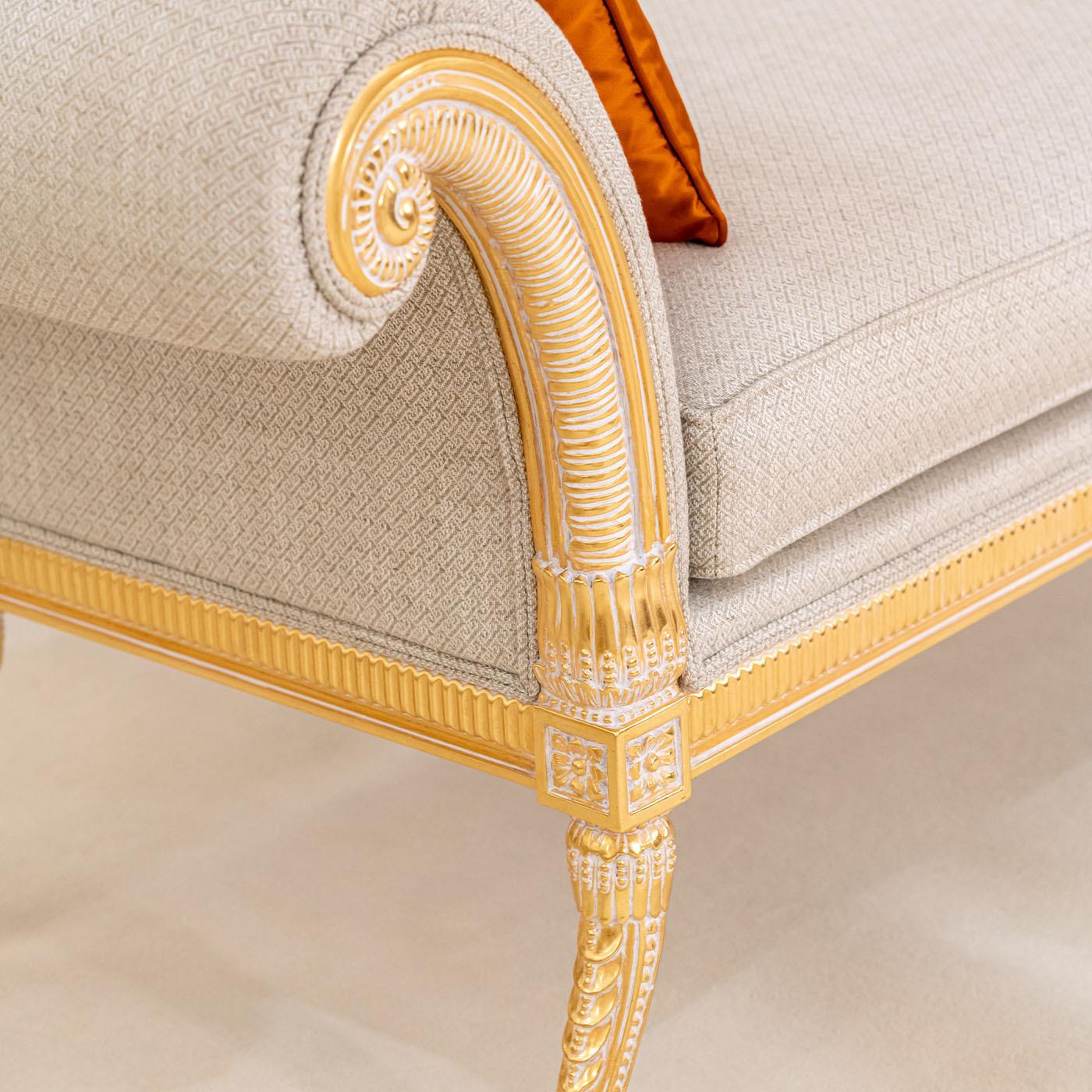Seductive with its curved sides accented by coils, this bench is a precious example of artisan design inspired by the luxuriousness of the Empire style. Gold leaf adds a mesmerizing sheen to the minutely carved profiles, which outline an elegant
