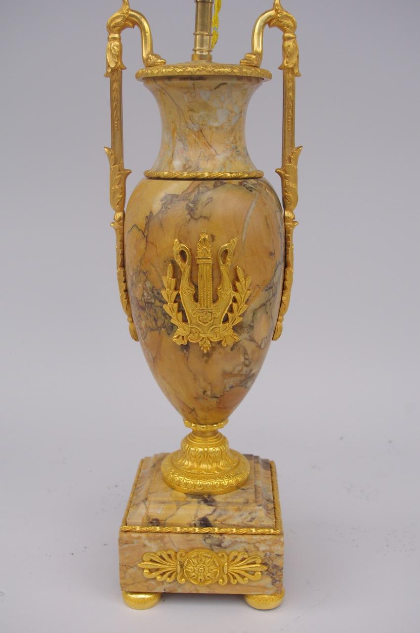 Pair of Empire style lamps made of Greek amphorae in Yellow Sienna marble standing in square base in the same material. Chiselled and gilt bronze mount with four legs, a gadrooned piedouche, foliage handles, empire style rosette surround of palm