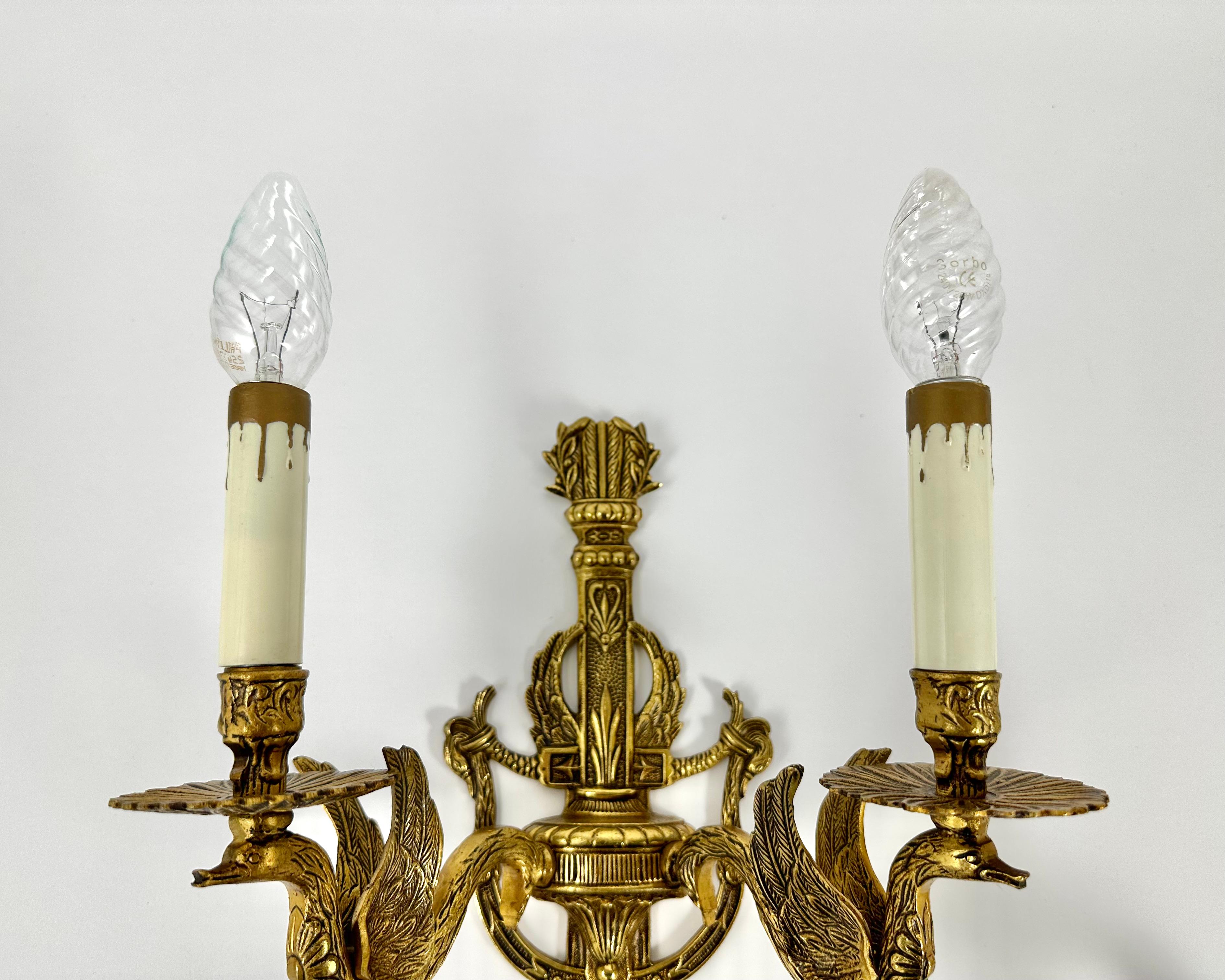 An exquisite pair of two-light Empire style gilt bronze wall sconces from the 1930s.

Drawing inspiration from the eighteenth century, these beautiful light fixtures demonstrate superb craft and detail along with their original gilded