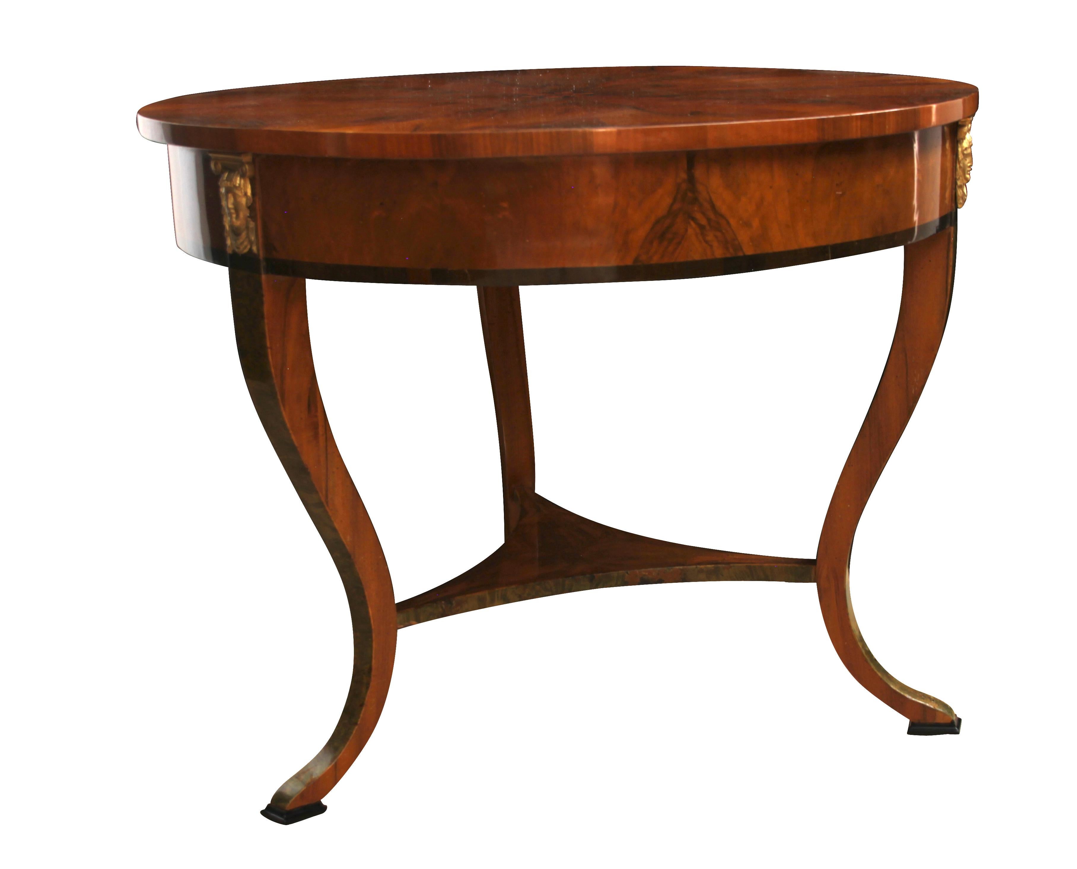 Wonderful round Empire table with three Caryatide heads at the sides and a beautiful star-shaped walnut veneer. The legs are very elegantly curved and have a middle tray in between. The table has several ebony inlays
and a green-colored birch root