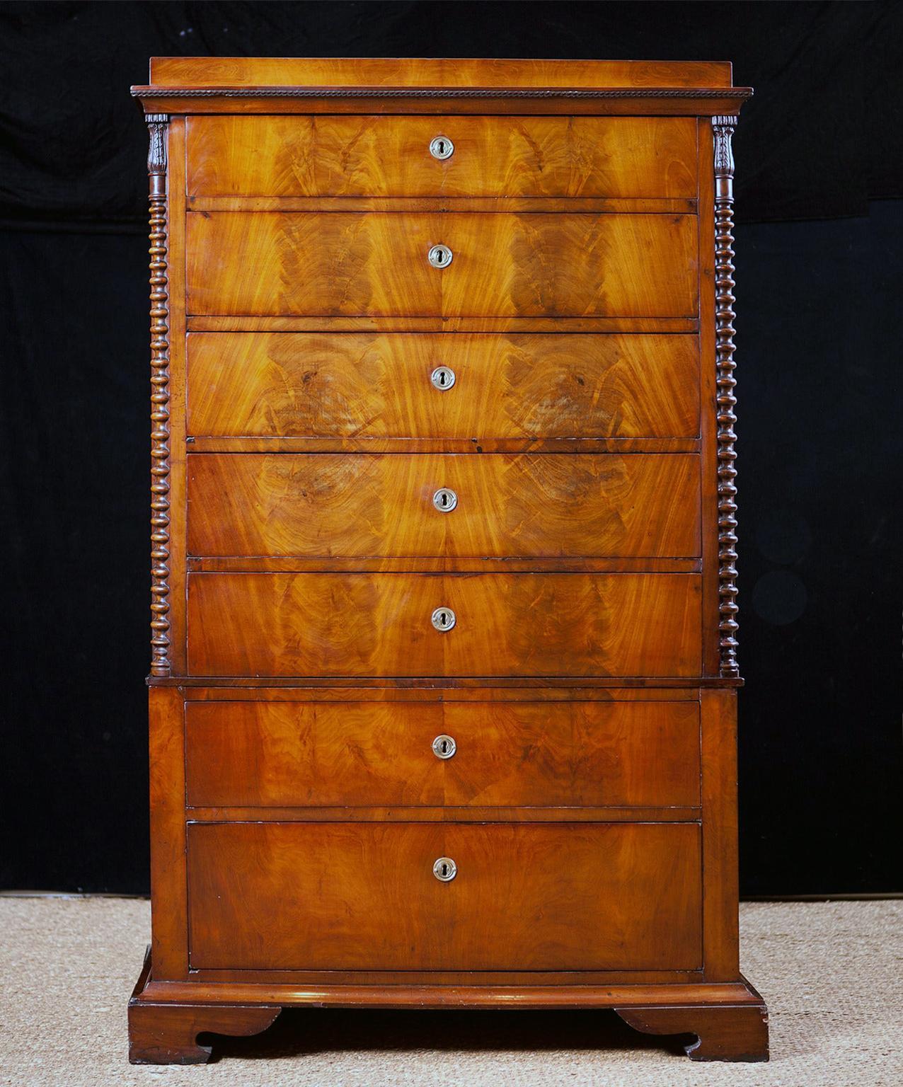 A very beautiful chest in fine West Indies/ Cuban mahogany with seven drawers. The upper part has a 3/4 spool-turned column with exquisitely carved capitals embellished with carved acanthus leaves. Chest rests on bracket feet. Denmark, circa 1825.