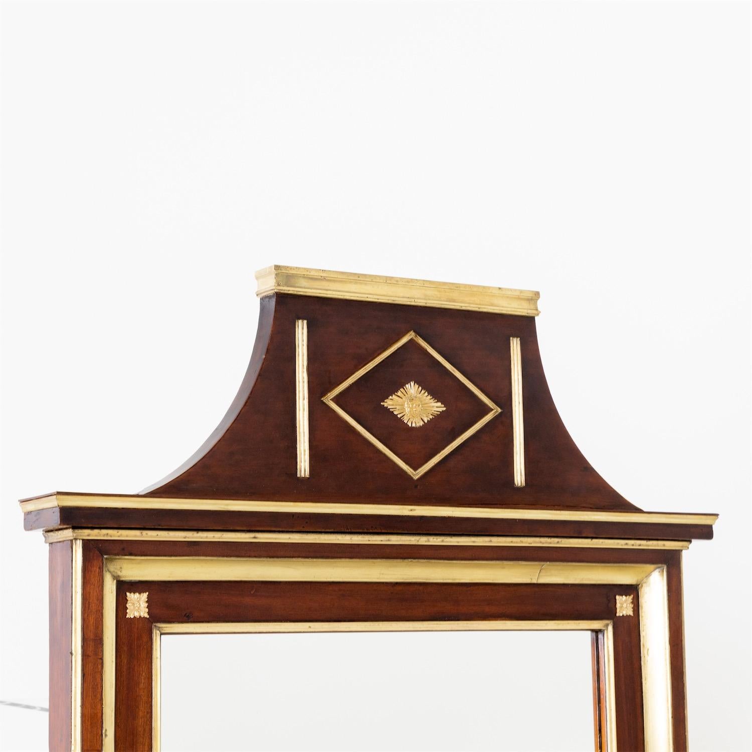 Russian pillar mirror in mahogany with brass molding and pedimented top.