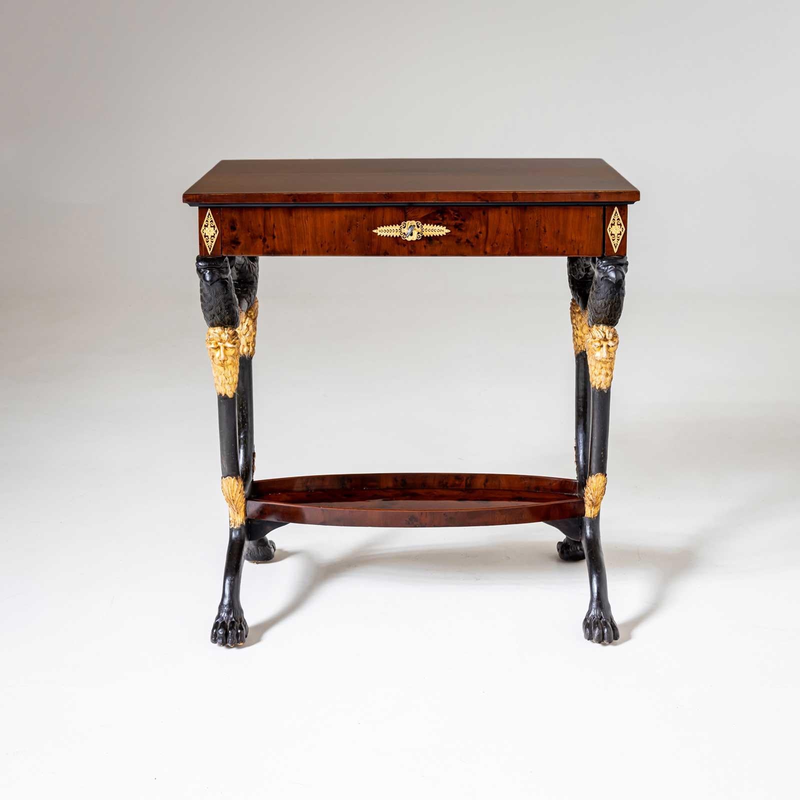 Tavolo da lavoro viennese rettangolare con un cassetto e raffinati accessori in bronzo. L'insolita cornice, in parte annerita e in parte patinata d'oro, presenta grifoni intagliati sopra teste di leone e zampe patinate d'oro. Il tavolo è in