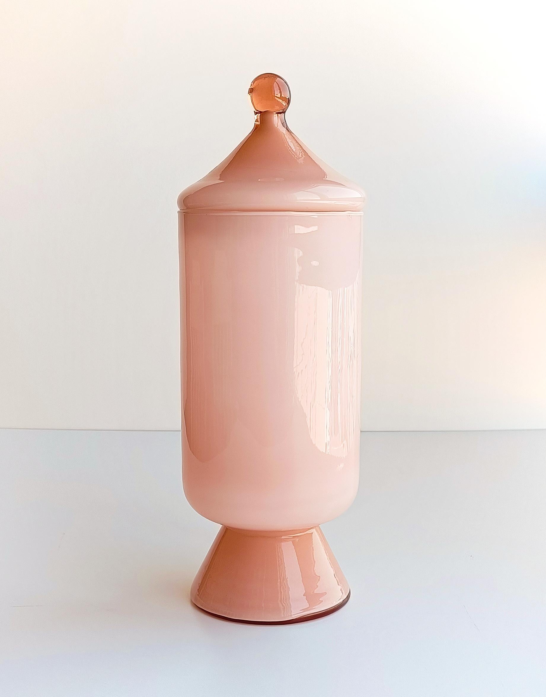 Stunning pale pink cased glass bombon jar, featuring a gorgeous circus tend lid and a sleek beyond chic design. The glass is thin and delicate. Exquisitely manufactured. Attributed to Carlo Moretti early years. Handcrafted in the island of Murano,
