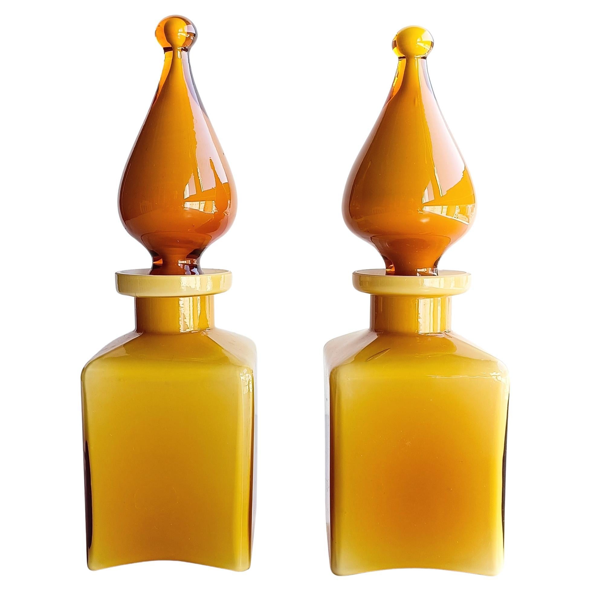 Delightful indeed, these unusual Empoli Glass pair of perfume genie bottles feature a beautiful amber color exterior layer of glass and a very thin white casing. The body of the bottle is very light, in contrast with the very heavy and solid genie