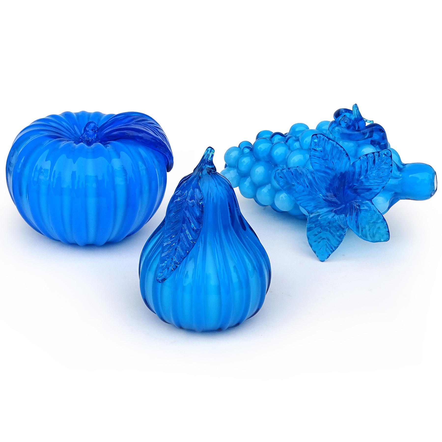 Beautiful vintage set of three hand blown electric blue Italian art glass fruit sculptural figural pieces. Attributed to the Empoli studio in Italy. The set includes a bunch of grapes with attached grape leaf and part of the vine curled on the side,