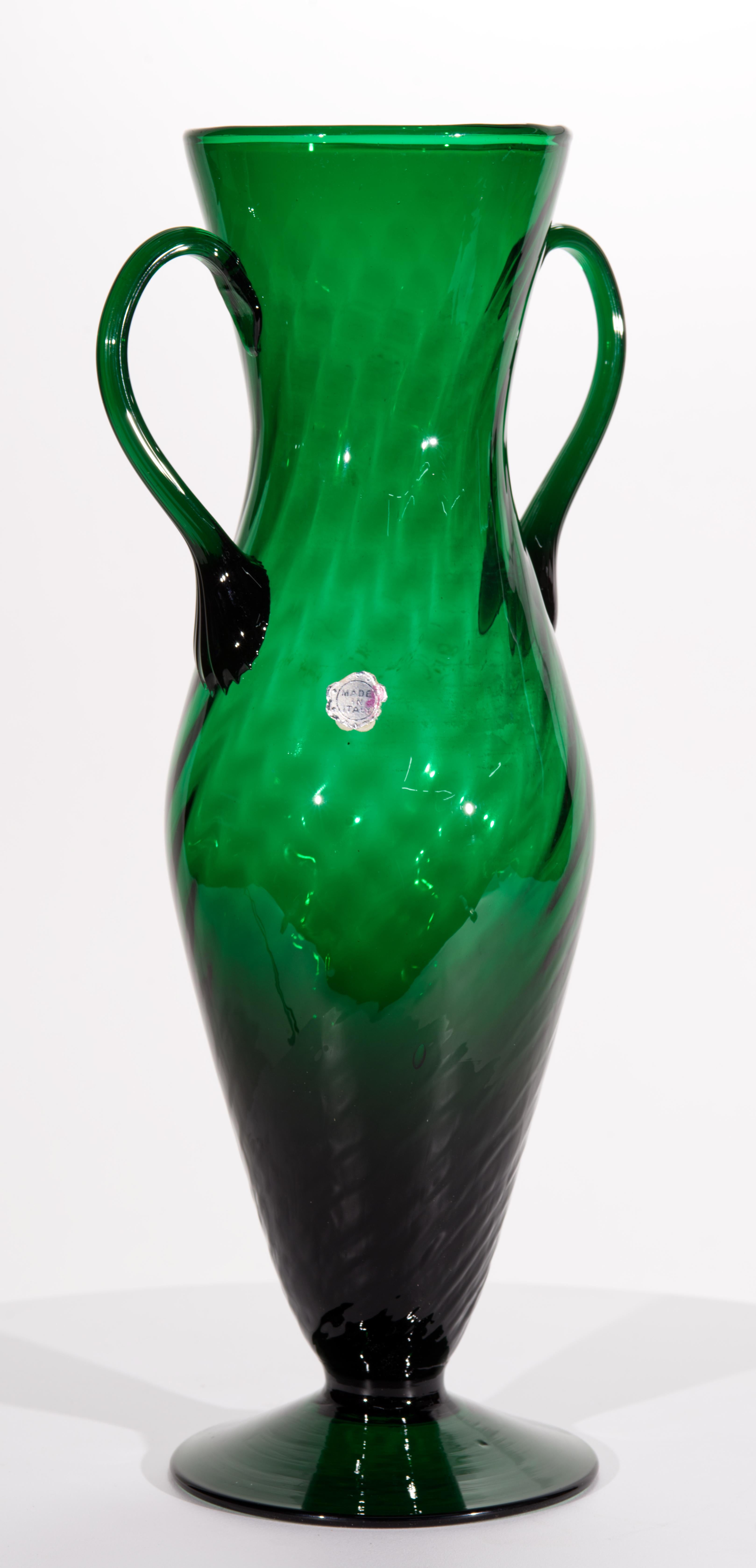  Vintage large, urn-shaped glass vase features elegant Op-Art design on the body of the vase and highly detailed ribbed handles. Monochromatic emerald green glass appears darker in thicker, heavier base and the handles, framing and showcasing the