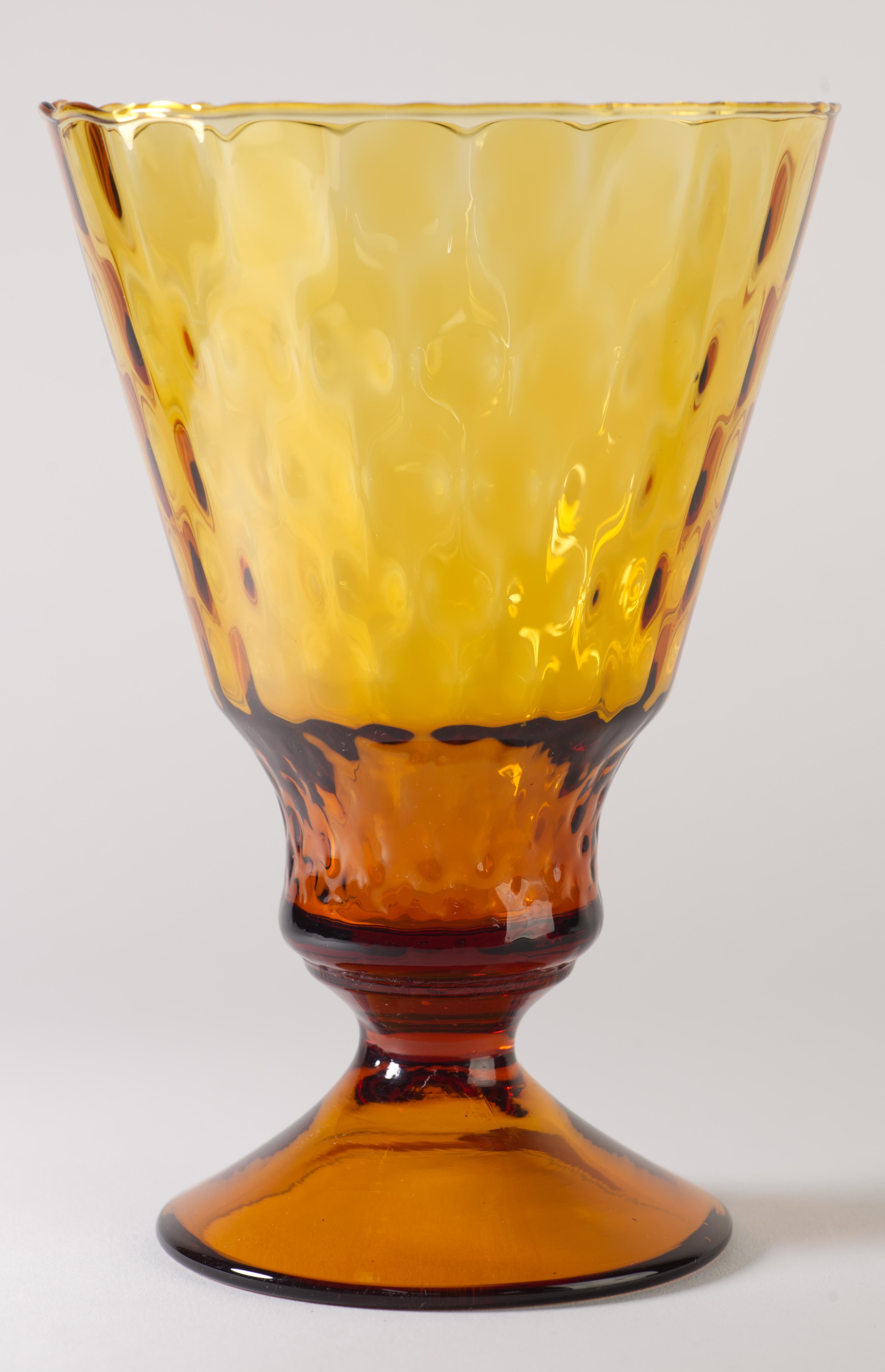  Striking vintage footed, goblet shaped vase was hand blown in amber glass with Op Art texture effect on the body of the vase and scalloped rim; the glass was manipulated to create an ombre effect with the dark amber base and foot of the vase and