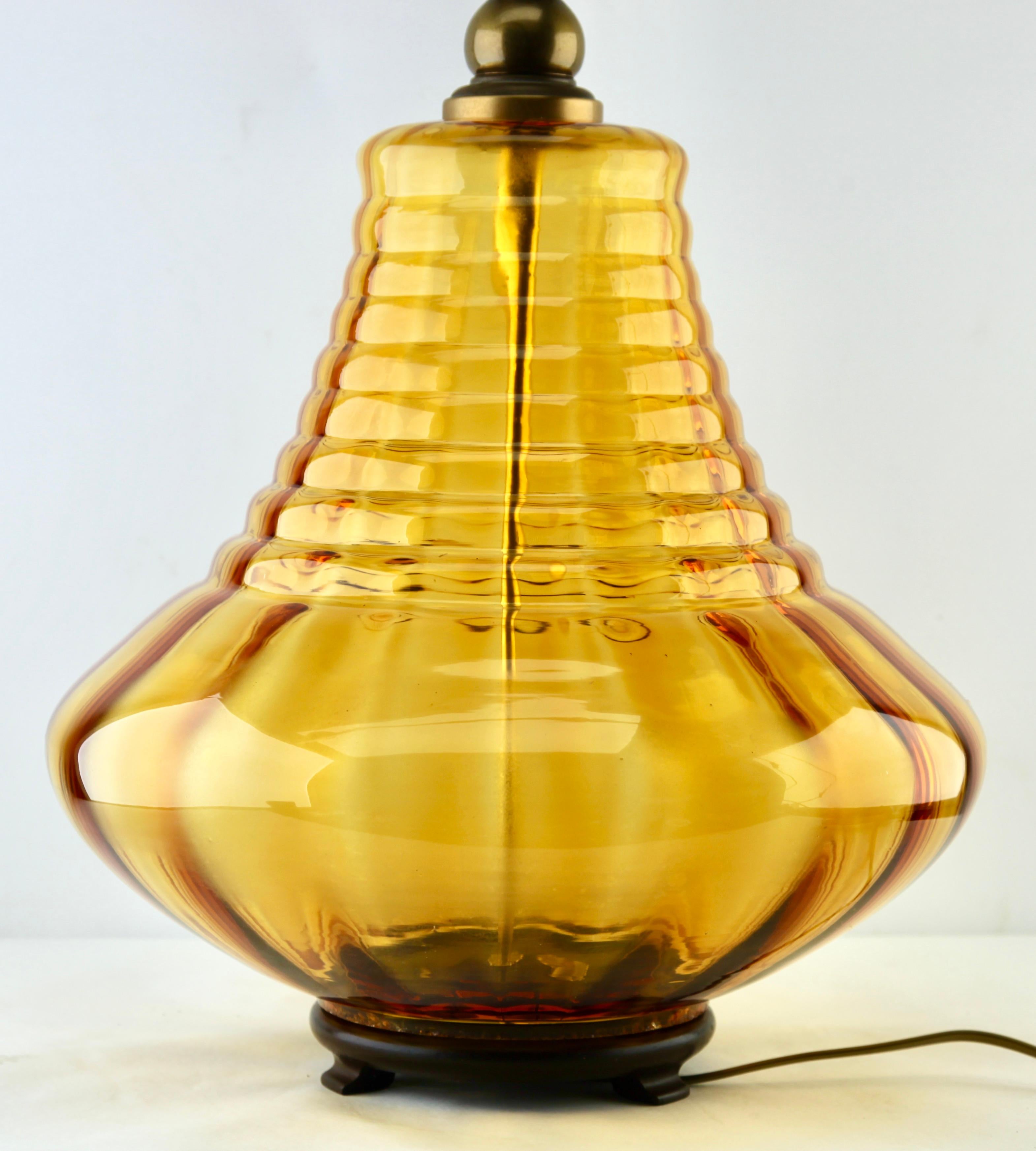 Italian glass table lamp with optical vertical-horizontal ribs
with a light amber tint
Made by Empoli in the midcentury.

Photography fails to capture the simple elegant illumination provided by this lamp.

In excellent condition having