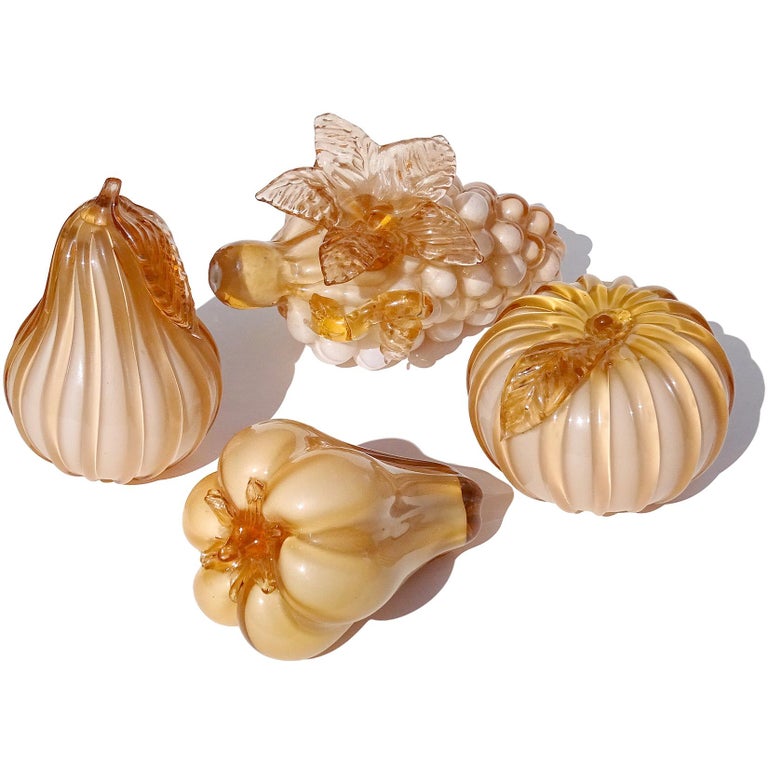 Beautiful vintage set of four hand blown peachy color Italian art glass fruit sculptural pieces. Attributed to the Empoli studio. It has an orange tint on the thicker glass parts. The set includes a bunch of grapes with attack grape leaf and part of