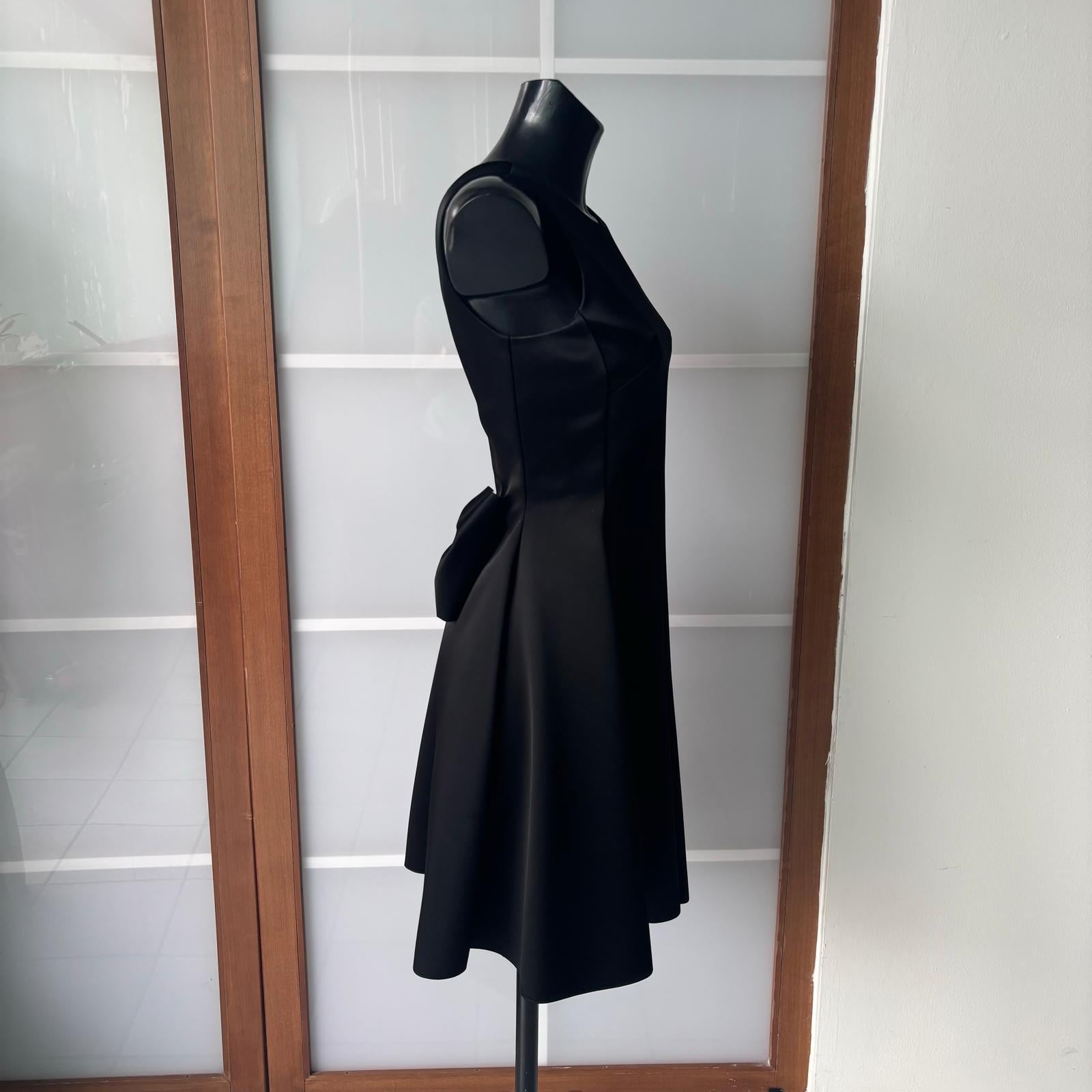 Raffinierter schwarzer Anzug von Emporio Armani, made in Italy, ein perfektes Beispiel für die zeitlose Eleganz des Hauses.
Das Design ist vorne minimalistisch, mit einem runden Ausschnitt und einer ausgestellten Linie, die die Silhouette betont,