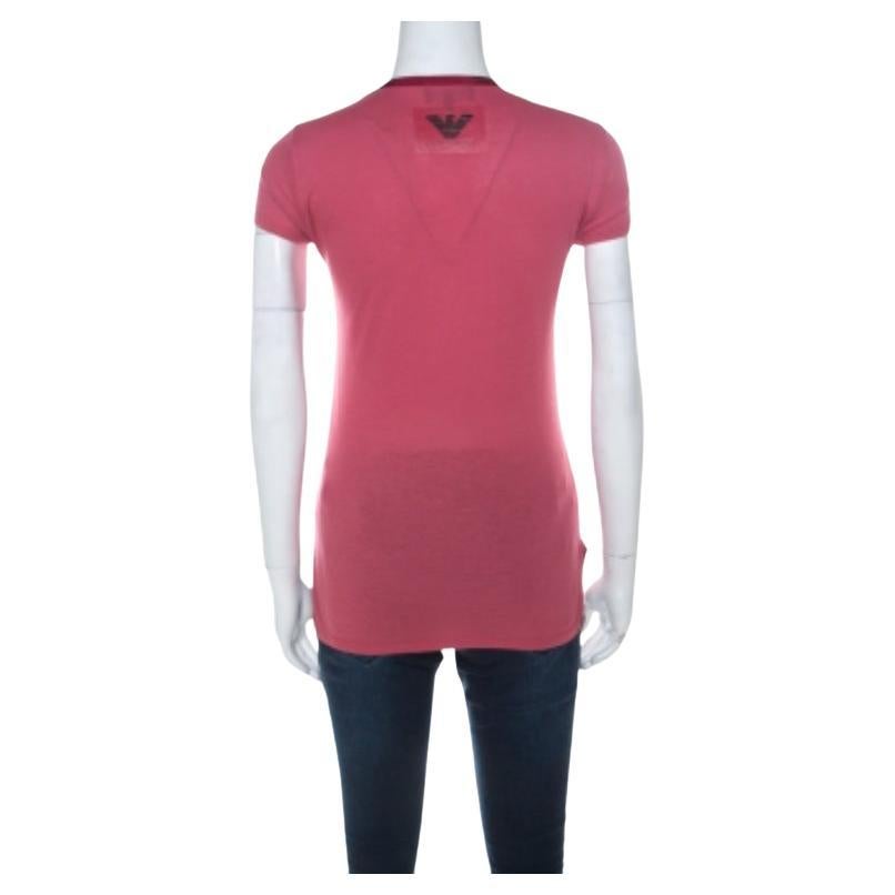 Dieses Emporio Armani-T-Shirt besticht durch sein schlichtes Design! Es ist mit einem tiefen Ausschnitt, kurzen Ärmeln und Logoprints auf der Vorderseite ausgestattet. Sie können dieses bequeme T-Shirt mit Skinny Jeans und flachen Schuhen
