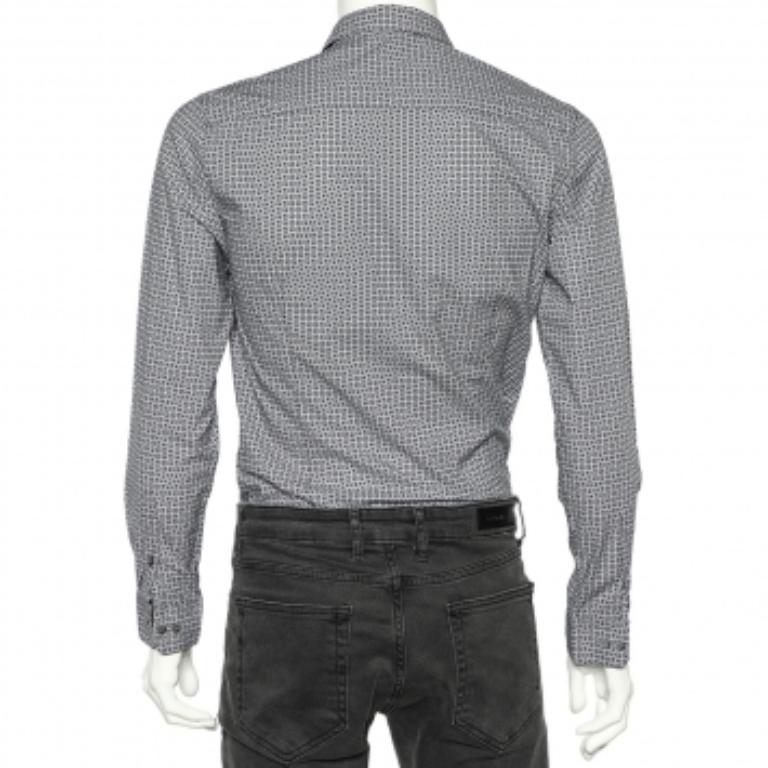 Esta camisa de la Casa Emporio Armani te garantiza una belleza clásica con un ajuste soberbio. Está confeccionado en un tejido de algodón azul con el logotipo estampado y presenta una silueta entallada. Tiene mangas largas, cuello y cierre