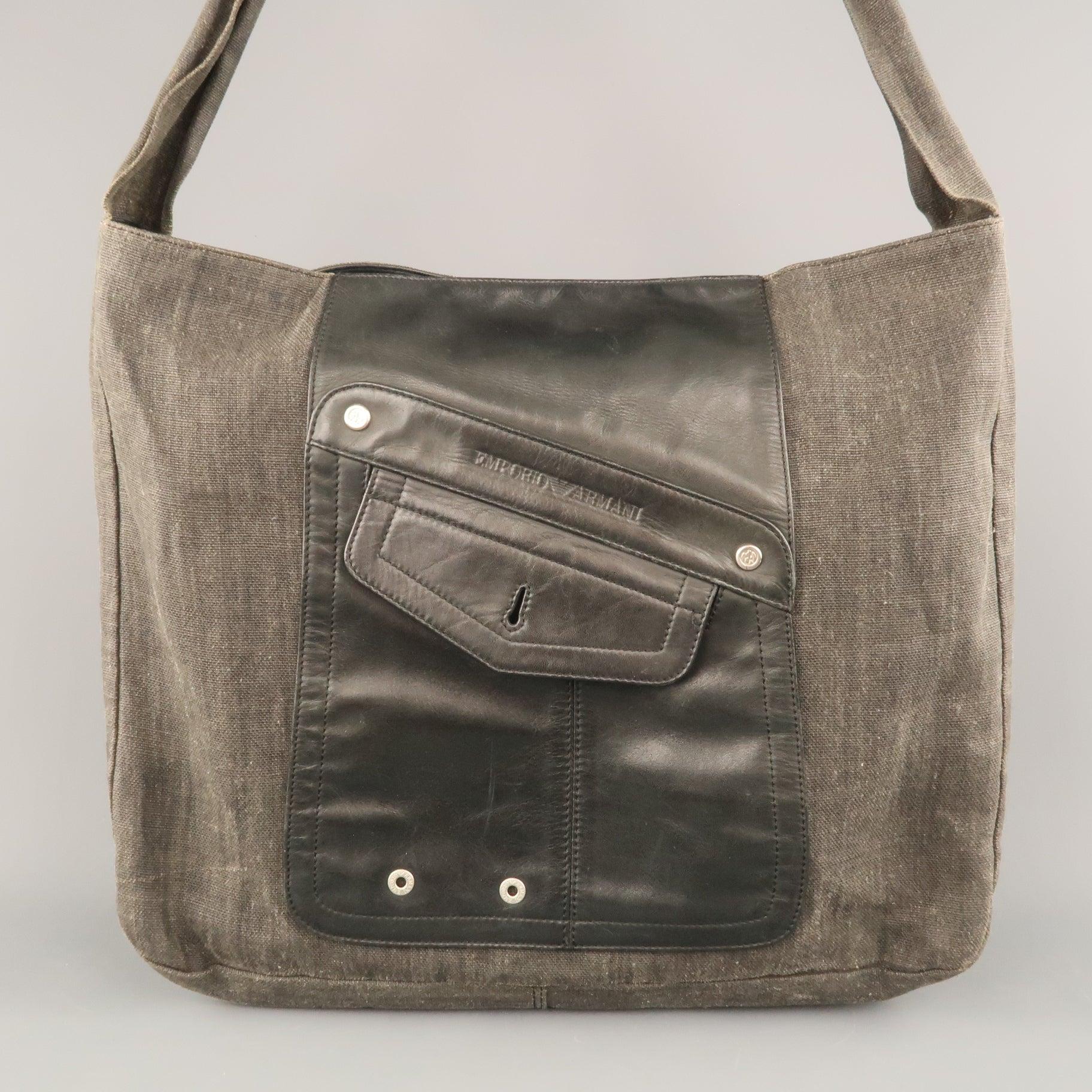 EMPORIO ARMANI oversized tote comes in charcoal coated canvas with a leather patch pocket front, top closure, and shoulder strap with leather stripe. . Made in Italy.Good Pre-Owned Condition.Wear throughout.
 

Measurements: 
  Length: 17 inches
