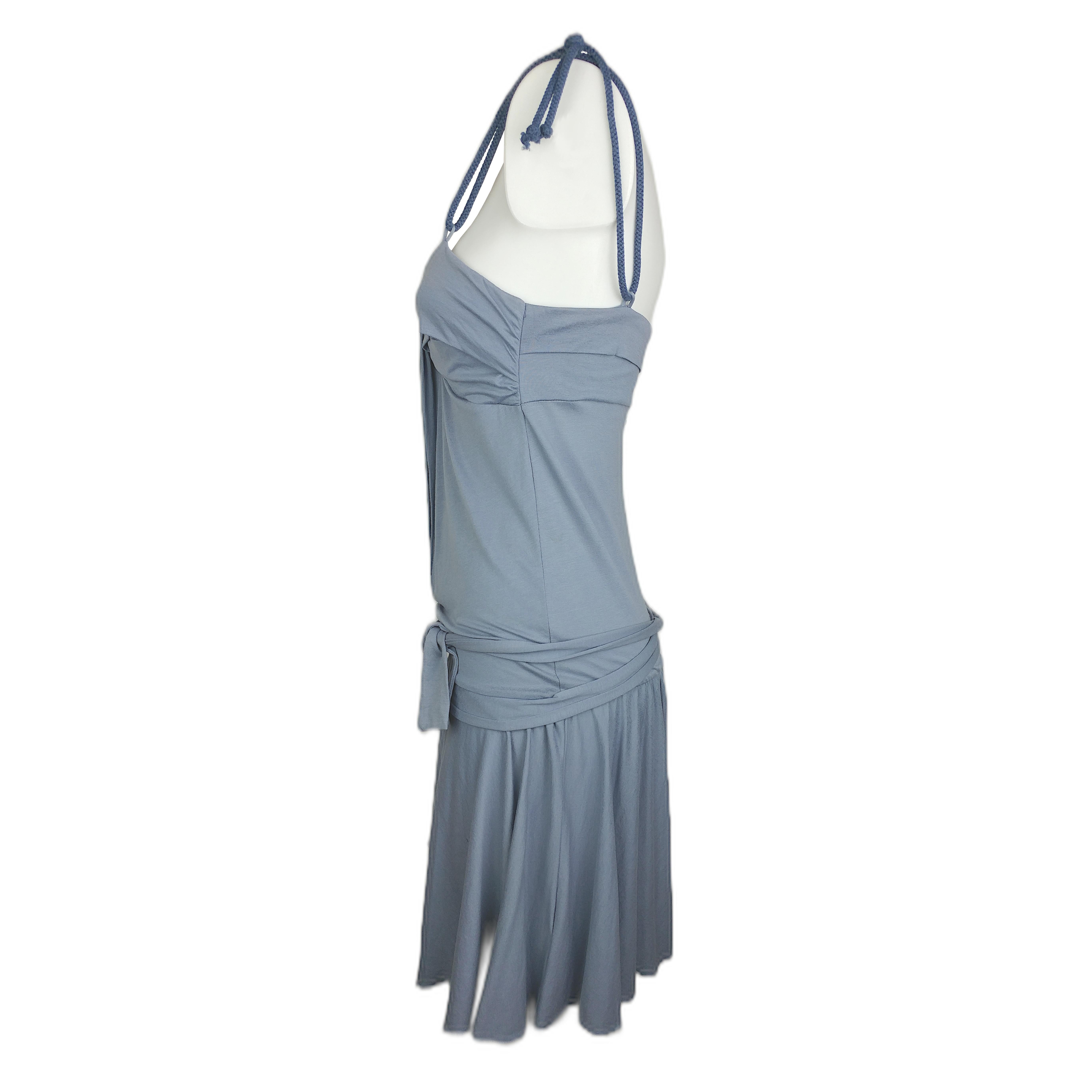 The turquoise dress we are offering has a full circle skirt and rope straps. It features a rear closure with three buttons, a waist belt made of the same fabric as the dress and it is very comfortable for any spring/summer event. It is in good
