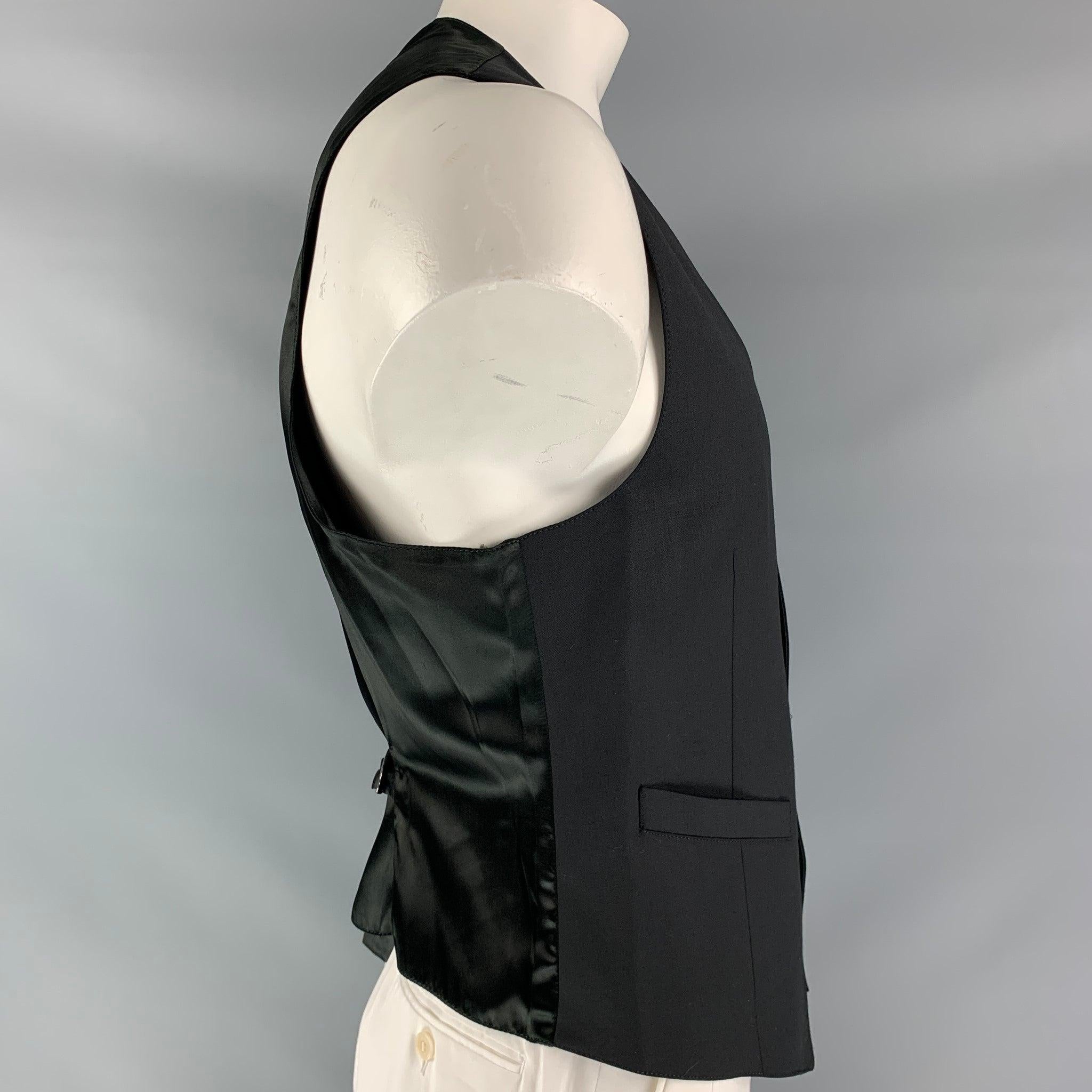 EMPORIO ARMANI green line dress vest comes in a black wool fabric, full lined featuring an asymmetric style, welt pockets, six buttons down closure, satin black fabric at back and adjustable back belt. Made in ItalyGood Pre-Owned Condition. Very