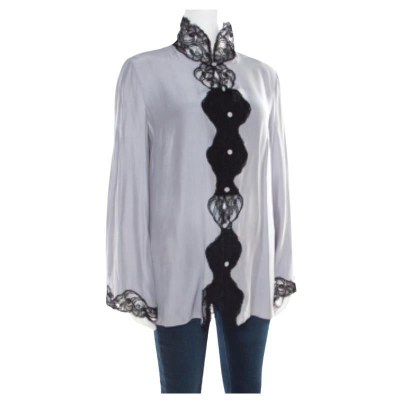 Emporio Armani ti propone questa splendida camicia che ti permetterà di ricevere complimenti ovunque tu vada! La camicia grigio perla è realizzata in seta al 100% e presenta un bellissimo pizzo floreale sul davanti e sul bordo delle maniche.