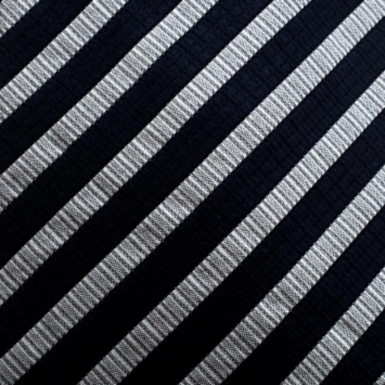 Luxueusement coupée dans de la soie, cette cravate sophistiquée provient de la maison Emporio Armani. Cette pièce présente des rayures bleu marine et grises, et le Label de la marque fait office de boucle de maintien au dos. Associez-le à une tenue
