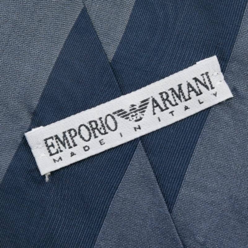 Dai un tocco di classe ai tuoi abiti da cerimonia con questa splendida cravatta della Maison Emporio Armani. È realizzato su misura con un tessuto di seta a righe blu navy. Ha una larghezza di 9 cm. Completa il tuo stile con raffinatezza indossando