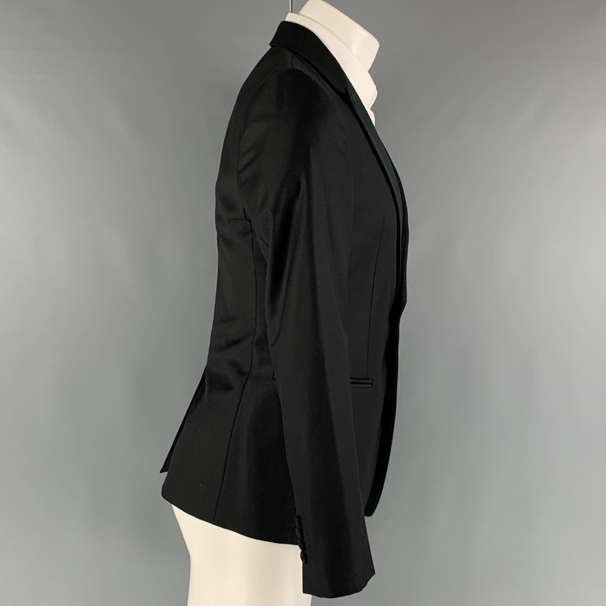EMPORIO ARMANI tuxedo sport coat comes in a black wool woven material with a full liner featuring a peak lapel, welt pockets, and a single button closure. Made in Italy. Very Good Pre-Owned Condition.
Minor signs of wear. 

Marked:   46