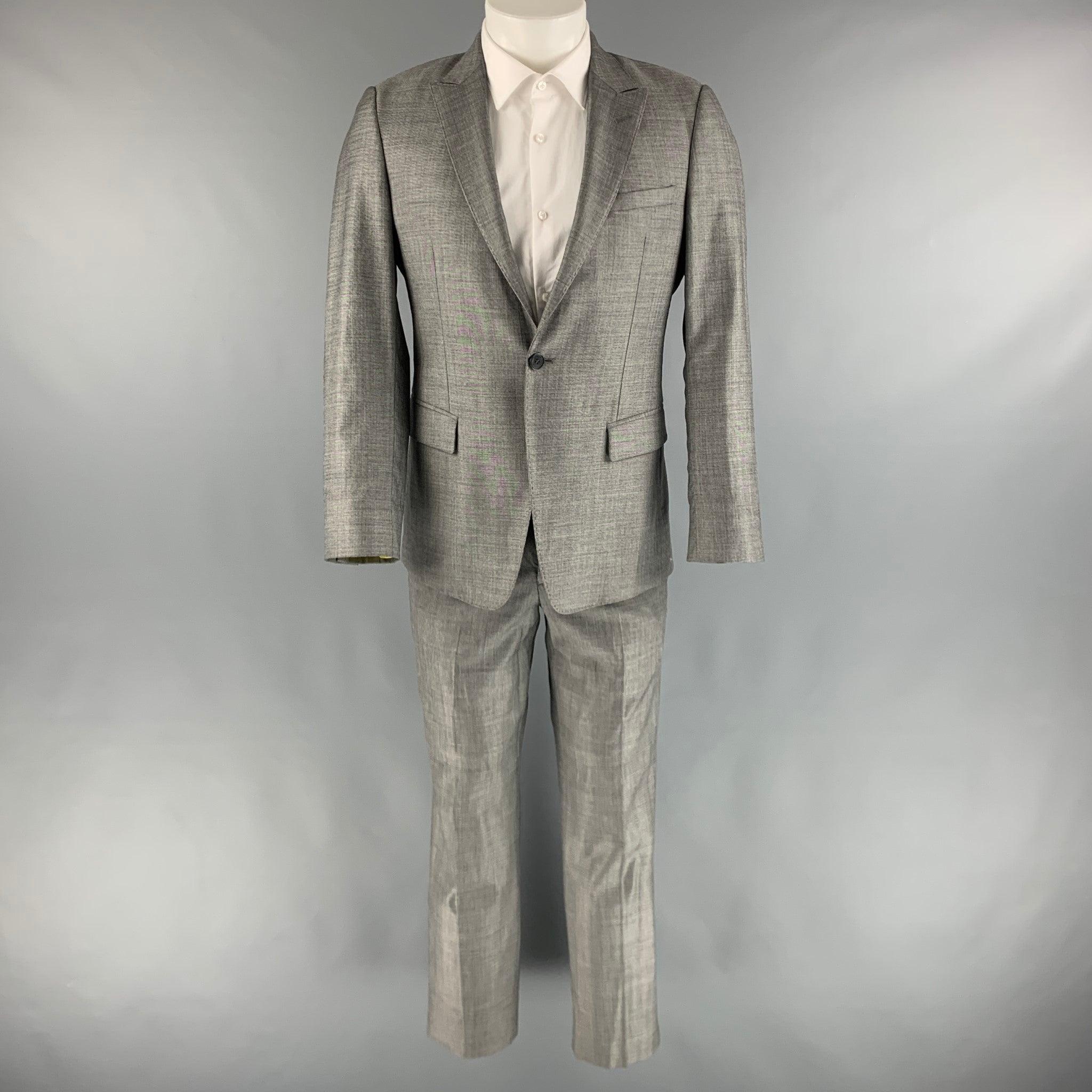 EMPORIO ARMANI suit comes in a grey wool and silk woven material with a full liner and includes a single breasted, single button sport coat with a peak lapel and a matching flat front trousers. Made in Italy.
Excellent Pre-Owned Condition. 
