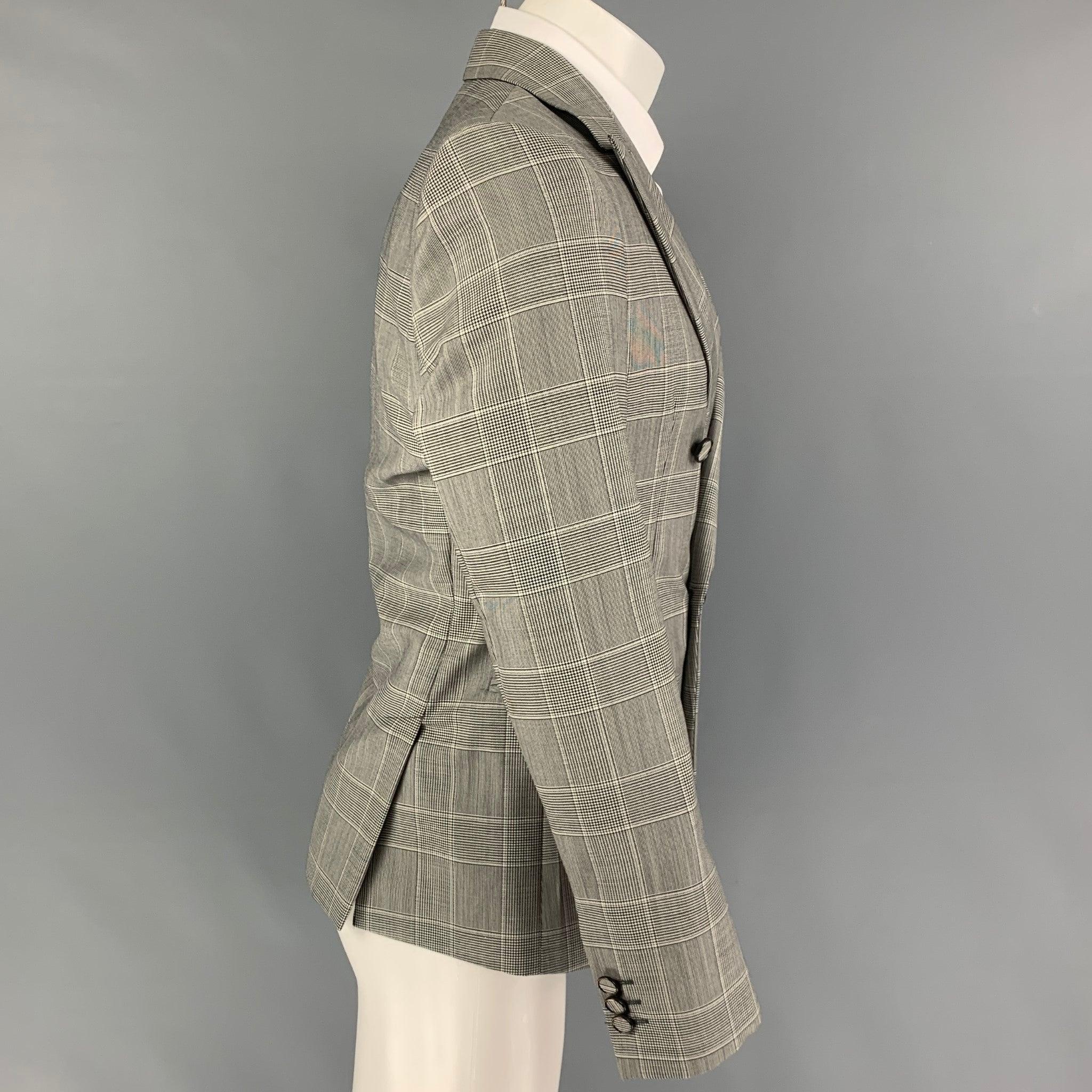 EMPORIO ARMANI
sport coat comes in a black & white glenplaid wool with a full liner featuring a peak lapel, slit pockets, double back vent, and a double breasted closure.
Made in Italy.Very Good Pre-Owned Condition.  

Marked:   48 

Measurements: 
