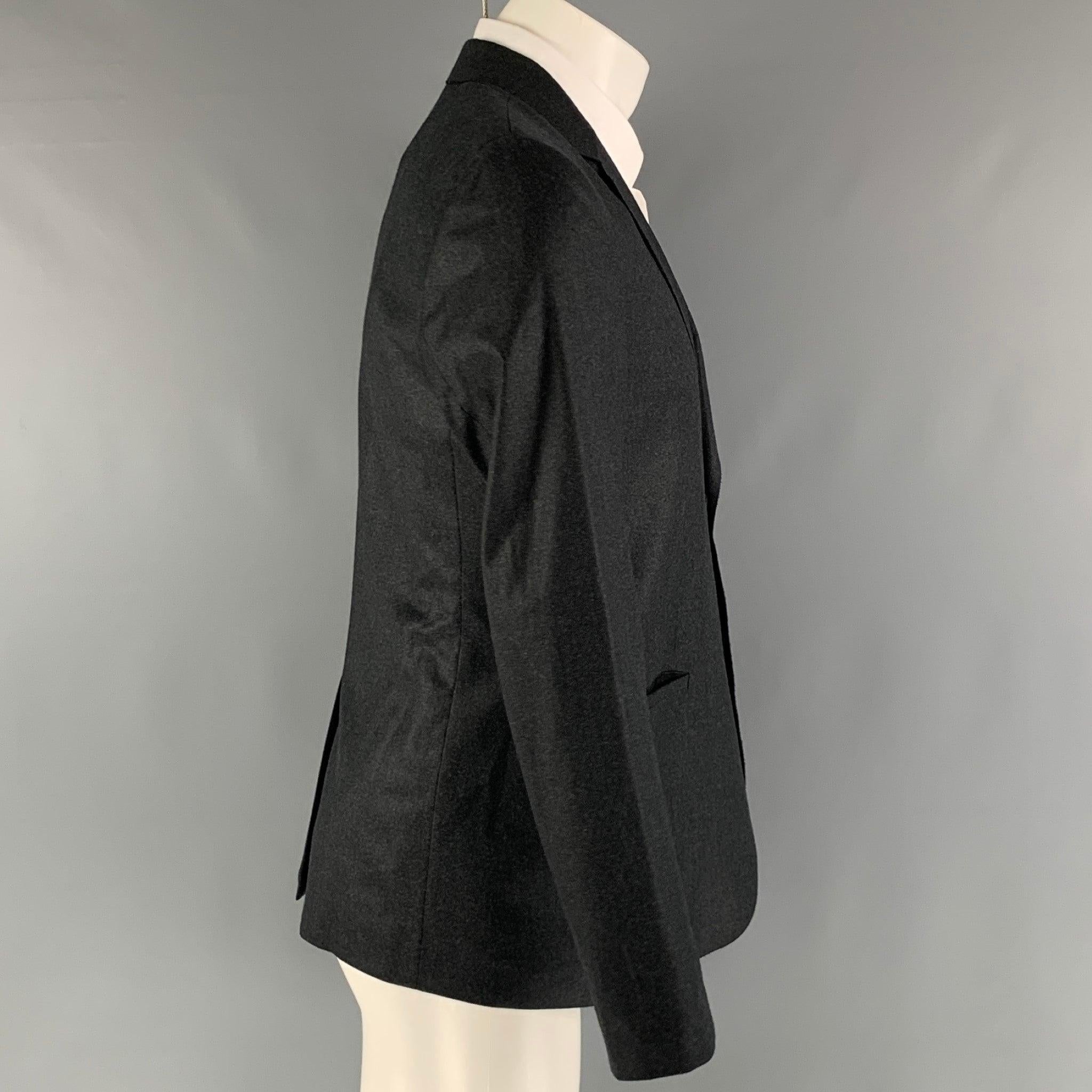EMPORIO ARMANI 'MILANO' sport coat comes in a charcoal wool woven material with a full liner featuring a notch lapel, welt pockets, and a two snap button closure. Made in Italy. Excellent Pre-Owned Condition. 

Marked:   48 

Measurements: 
