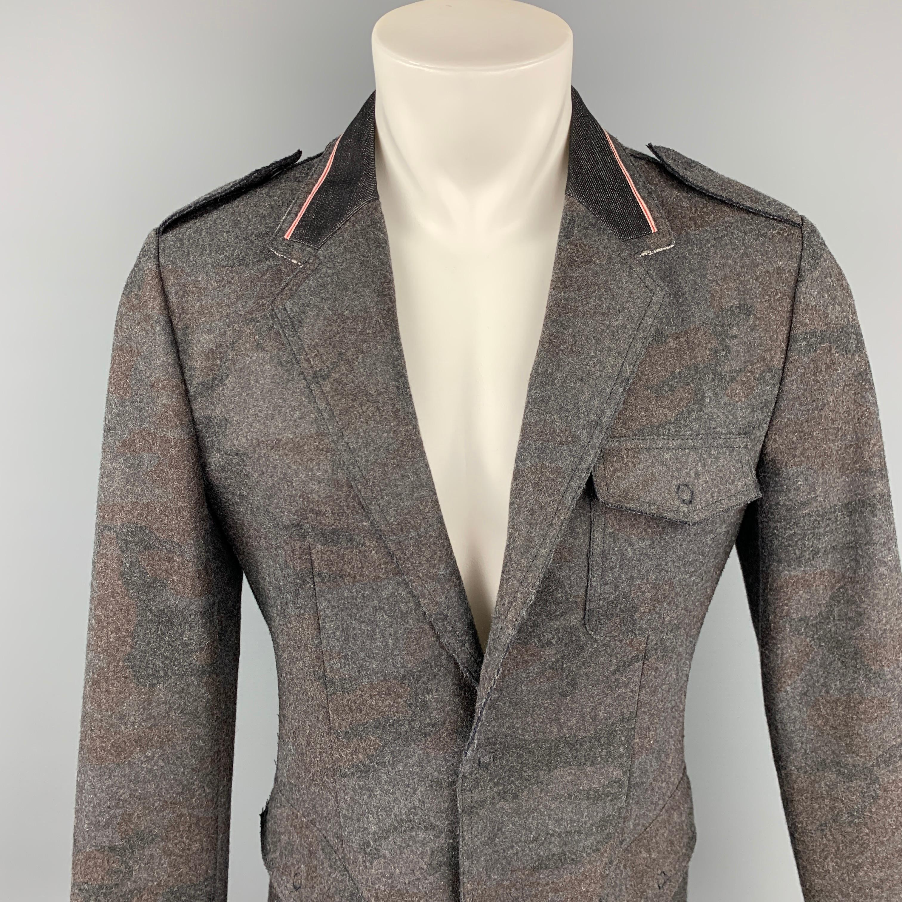 EMPORIO ARMANI jacket comes in a dark gray camouflage material with a denim collar featuring a notch lapel, flap pockets, and a snap button closure. Made in Italy.

Very Good Pre-Owned Condition.
Marked: No size marked

Measurements:

Shoulder: 17.5