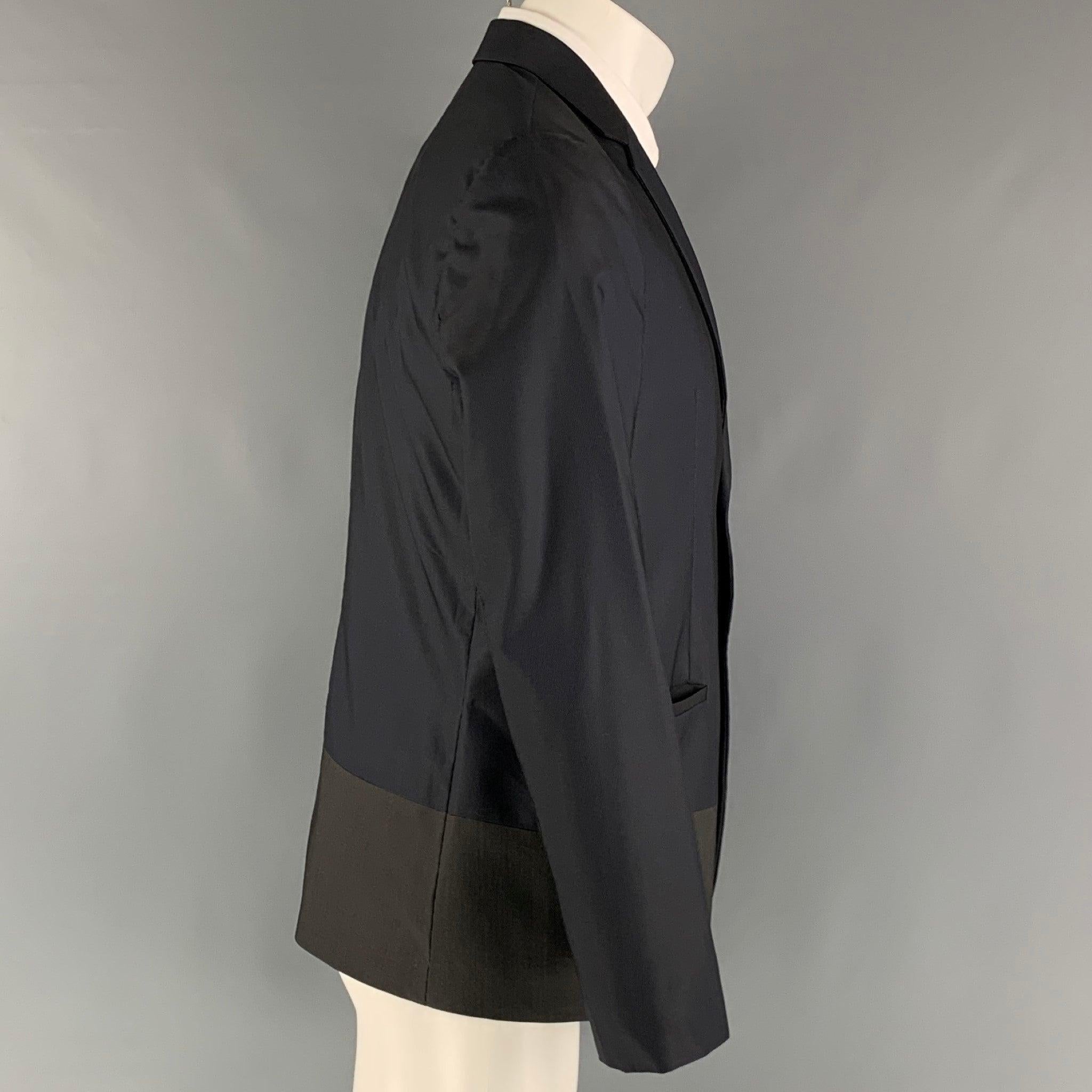 EMPORIO ARMANI sport coat comes in a navy and olive woven material with full lining featuring a color block aesthetic, notch lapel, welt pockets, and a two button closure. Made in Italy.Excellent Pre-Owned Condition. 

Marked:   IT 48