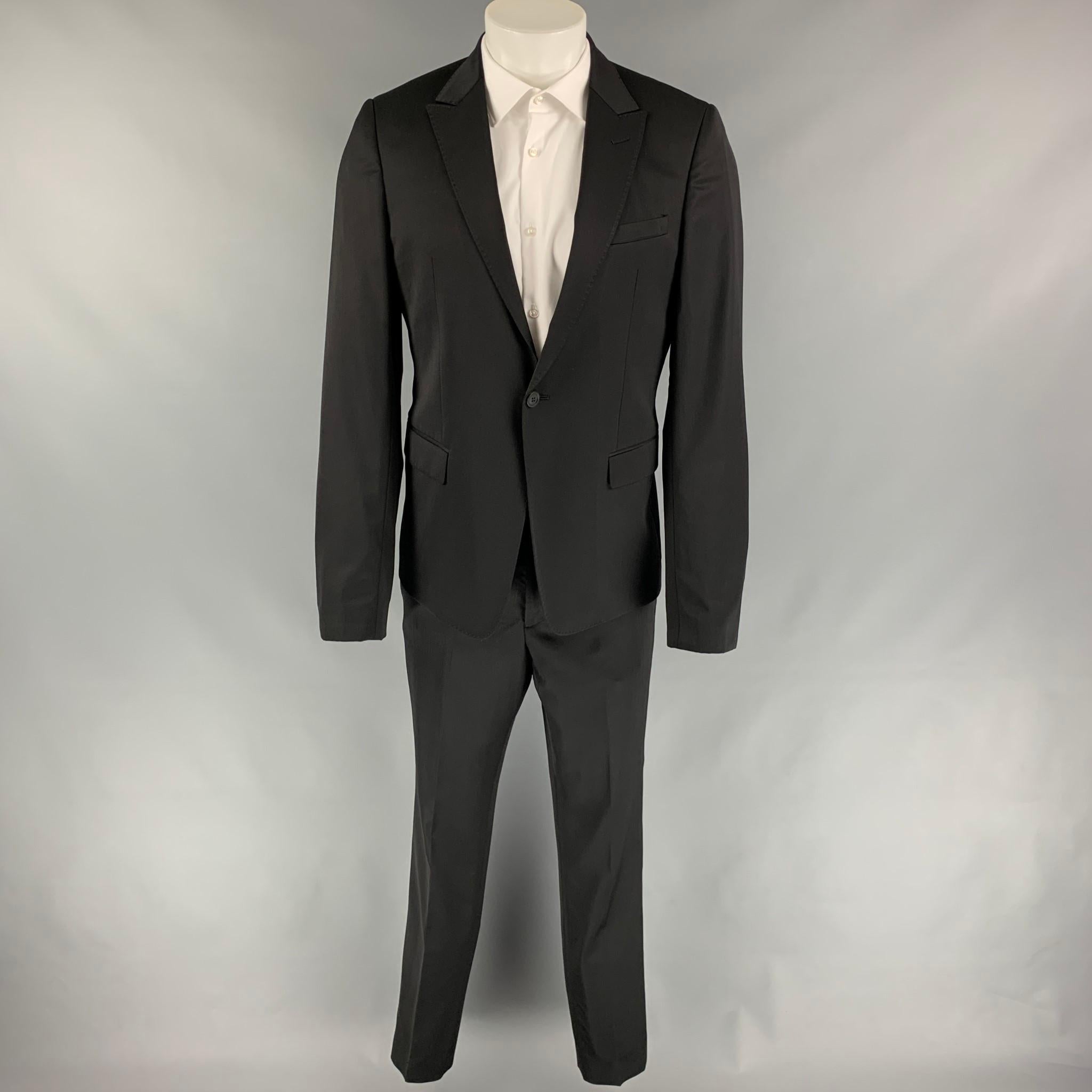 EMPORIO ARMANI suit comes in a black virgin wool / polyamide with a full liner and includes a single breasted, two button sport coat with a peak lapel and matching flat front trousers. Made in Italy.

Very Good Pre-Owned Condition.
Marked: