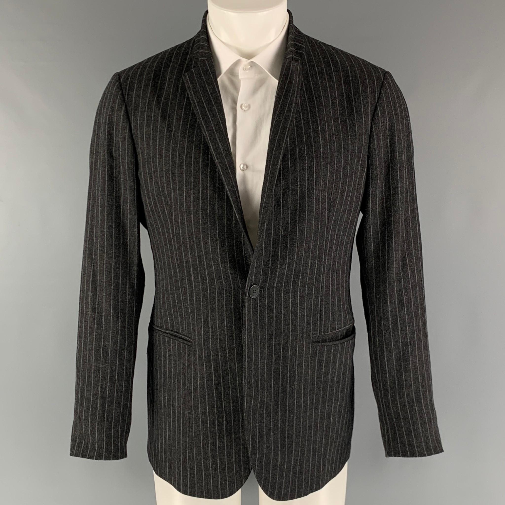EMPORIO ARMANI 'Johnny Line' sport coat comes in a grey and charcoal wool chalk striped woven material full liner featuring a high collar, welt pockets, single back vent, and a single button closure. Made in Italy.

Excellent Pre-Owned