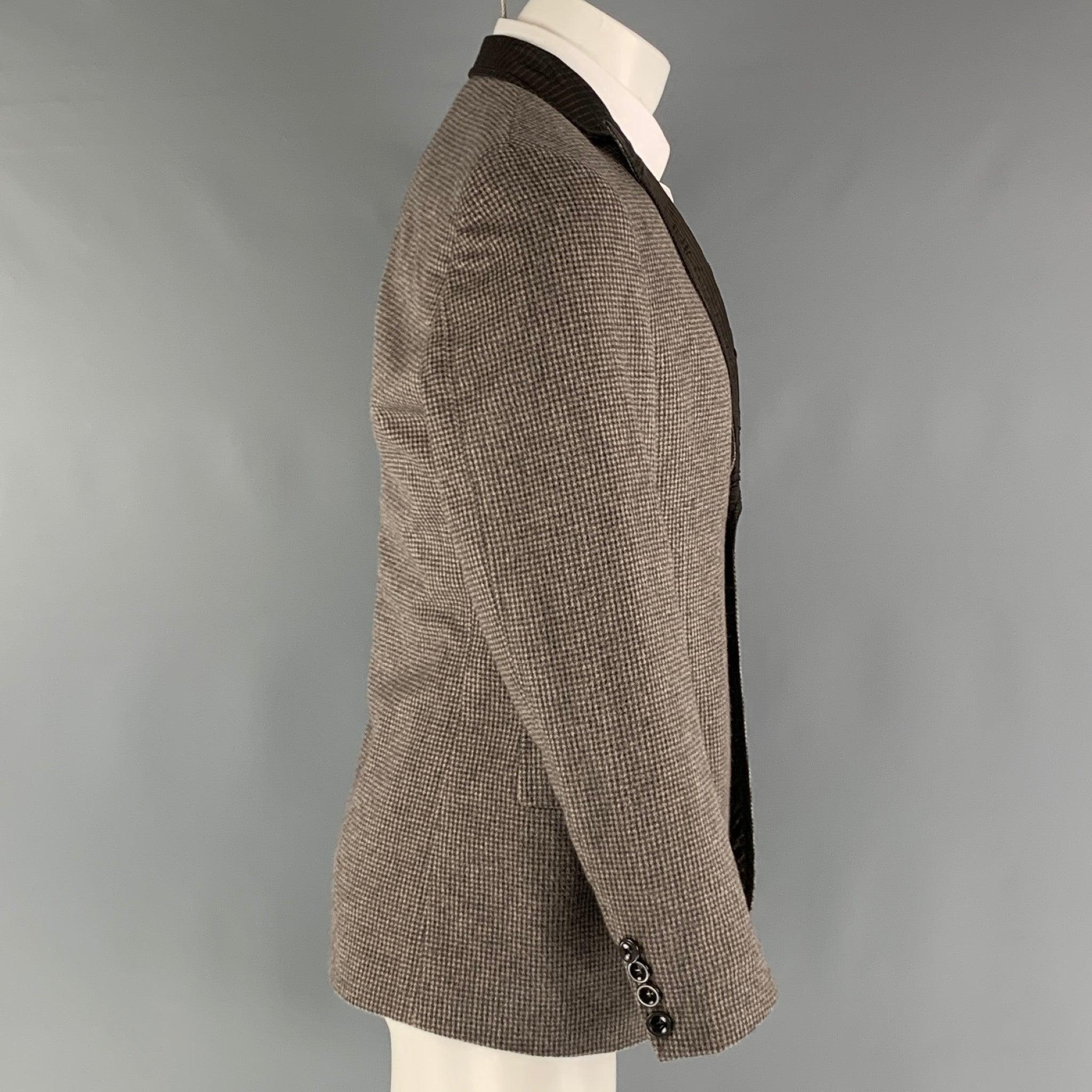 EMPORIO ARMANI sport coat comes in a brown, charcoal and grey checkered angora woven material with full lining featuring a peak lapel, patch pockets, and a two button closure. Made in Italy.Excellent Pre-Owned Condition. 

Marked:   IT 50