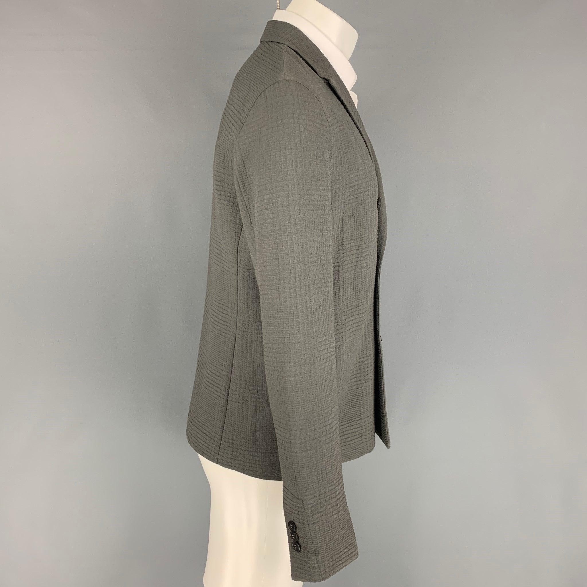 EMPORIO ARMANI sport coat comes in a slate textured material featuring a peak lapel, slit pockets, and a double breasted closure. Made in Italy.
Very Good
Pre-Owned Condition. Fabric tag removed.  

Marked:   Size tag removed.  

Measurements: 
