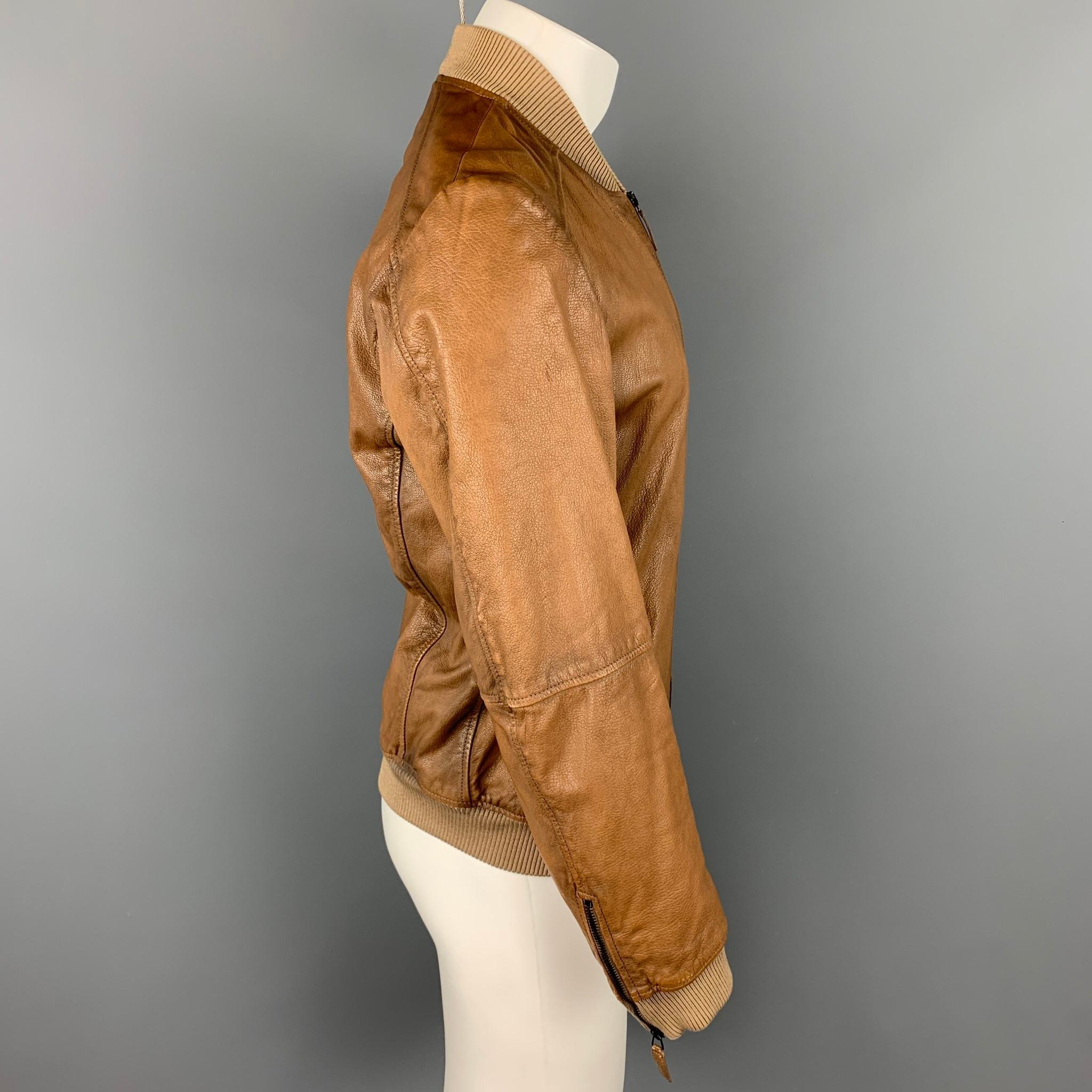 EMPORIO ARMANI jacket comes in a tan leather with a full liner featuring a bomber style, zipper pockets, ribbed hem, and a zip up closure.

Good Pre-Owned Condition.
Marked: TG 50

Measurements:

Shoulder: 18 in.
Chest: 40 in.
Sleeve: 26 in.
Length: