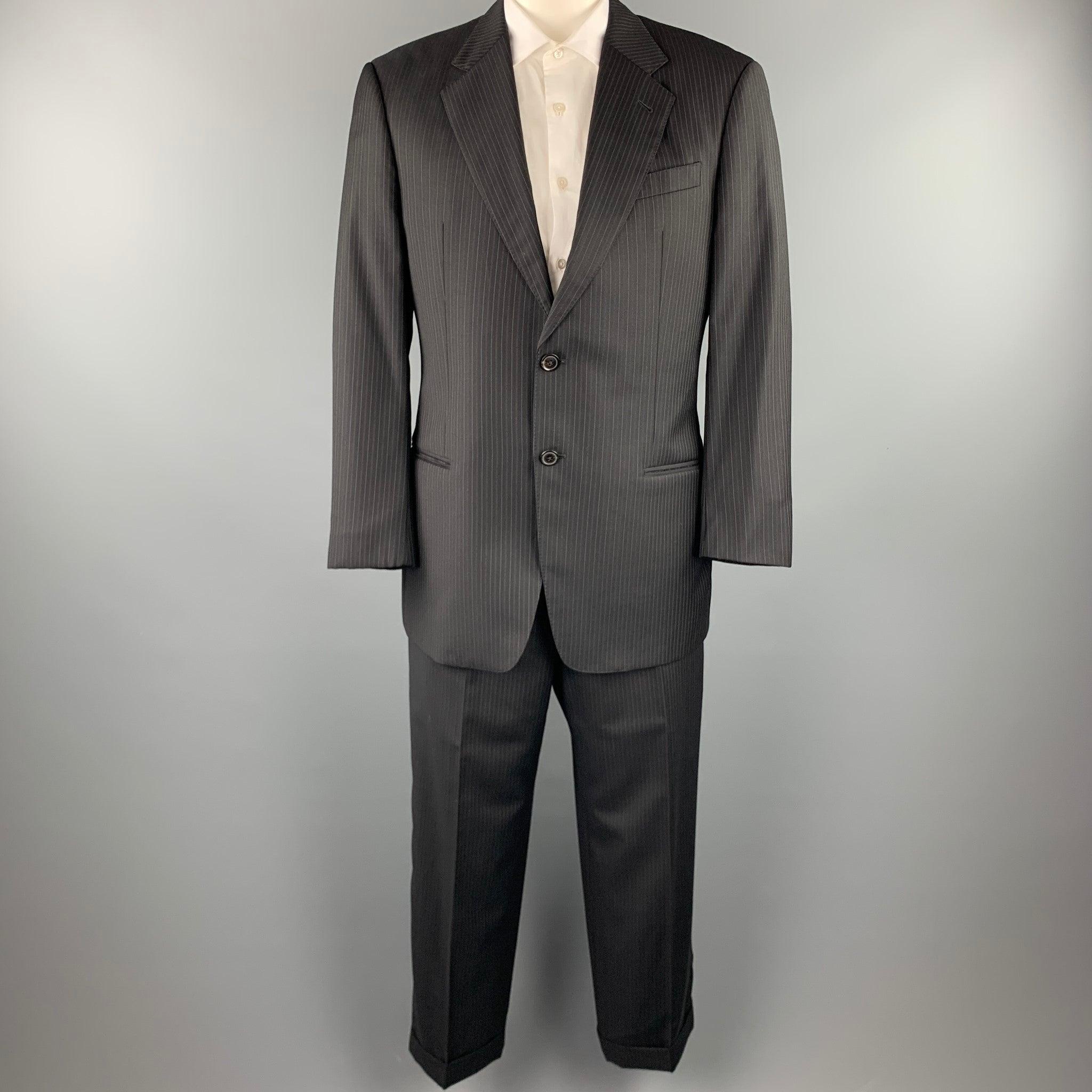 EMPORIO ARMANI
suit comes in a black stripe wool with a full liner and includes a single breasted, two button sport coat with a notch lapel and matching flay front trousers. Made in Italy.Very Good Pre-Owned Condition. 

Marked:   42 R
