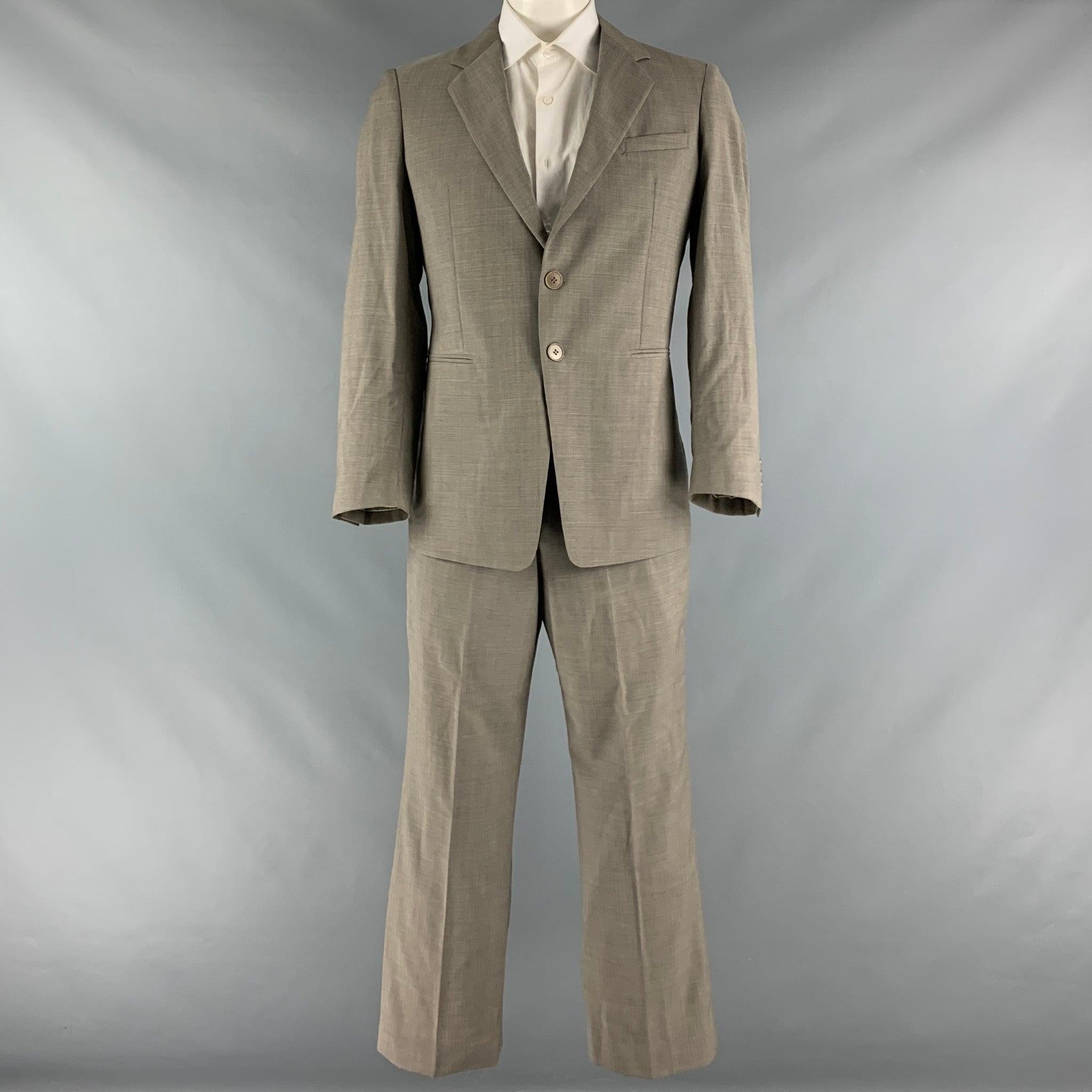 EMPORIO ARMANI suit comes in a taupe wool with a full liner and includes a single breasted, double button sport coat with a notch lapel and matching flat front trousers. Made in Italy.Excellent Pre-Owned Condition. 

Marked:   52/41 

Measurements: