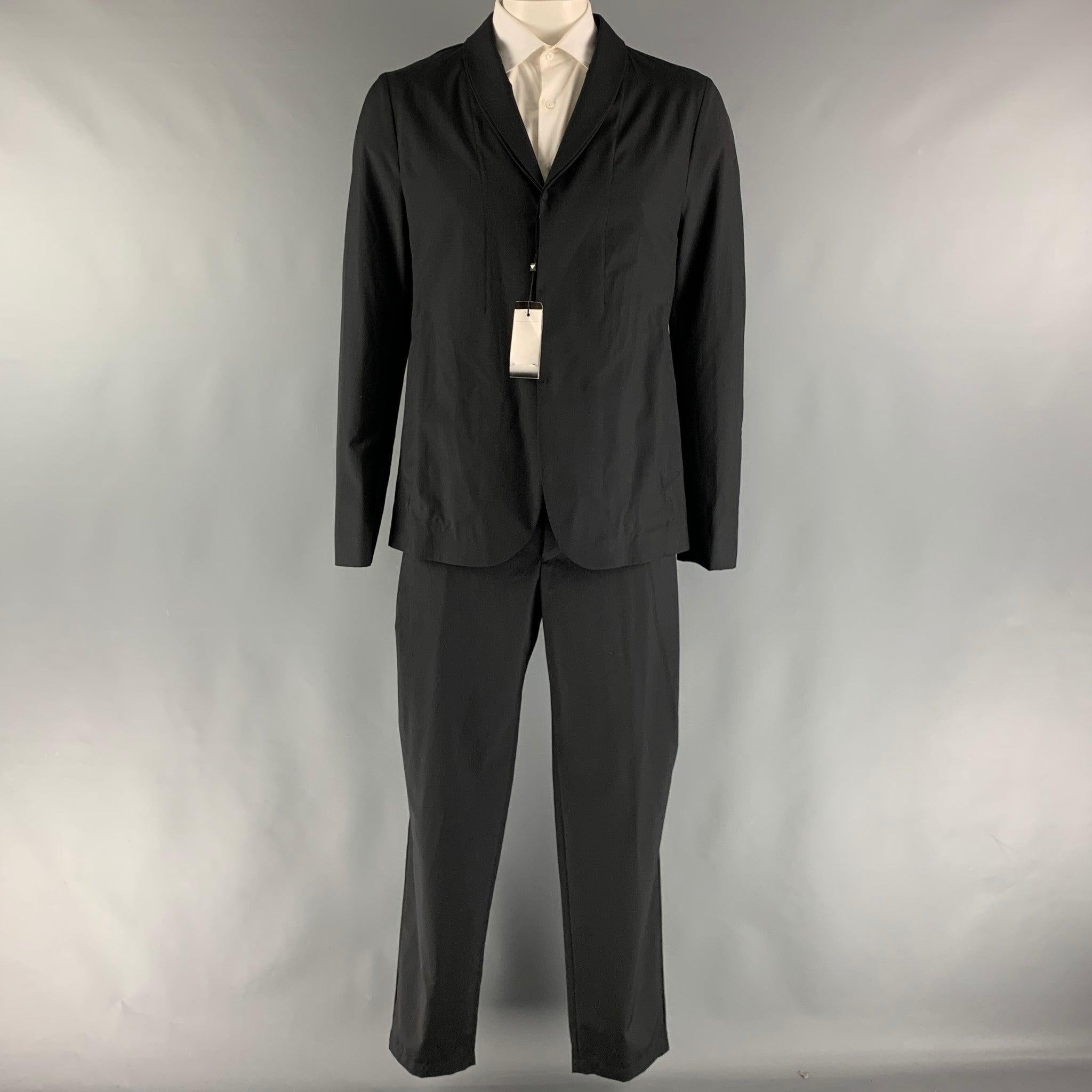 EMPORIO ARMANI suit comes in a black wool and silk woven material with a no lining and includes a single breasted, hidden placket button sport coat with a shawl collar and matching adjustable waistband trousers.
Made in Italy.New with Tags.