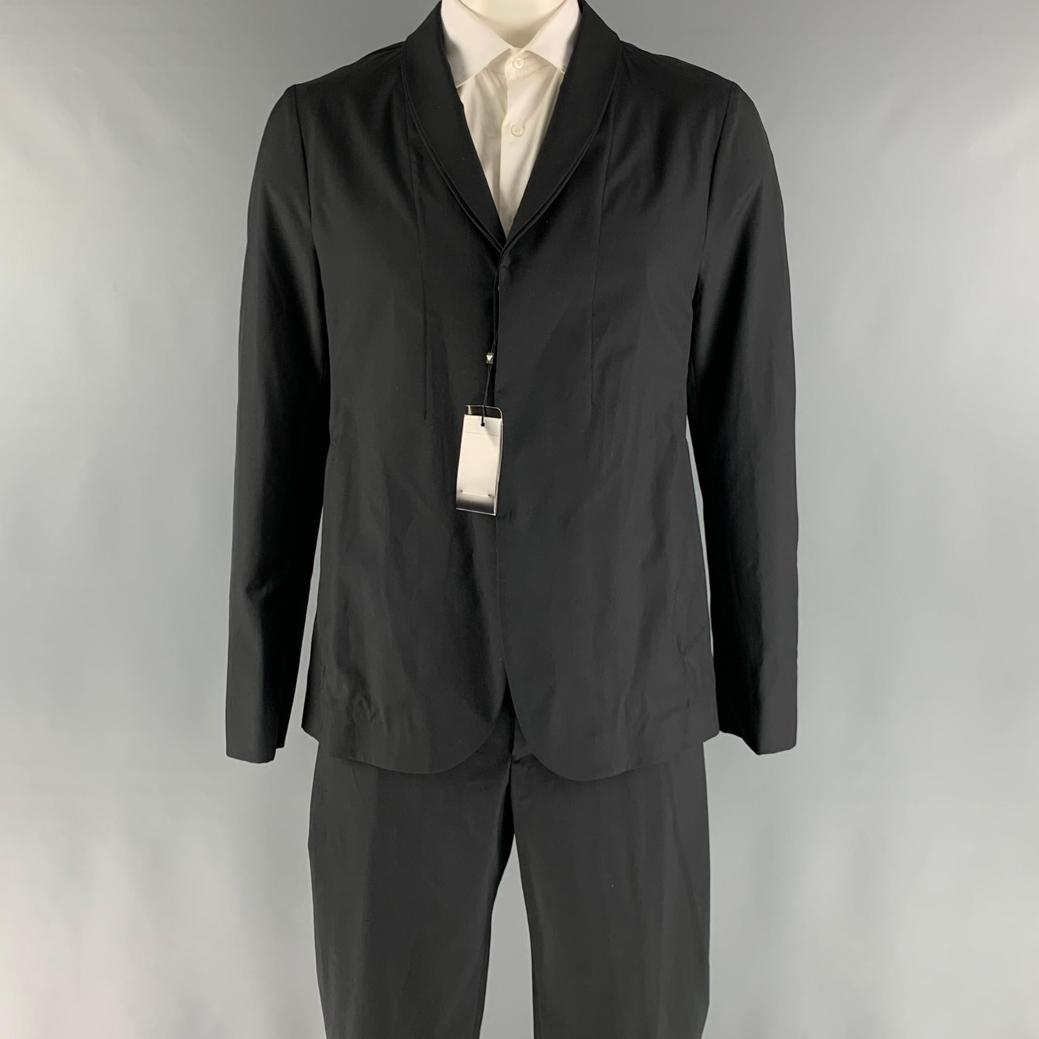 EMPORIO ARMANI suit comes in a black wool and silk woven material with a no lining and includes a single breasted, hidden placket button sport coat with a shawl collar and matching adjustable waistband trousers. Made in Italy.

New with